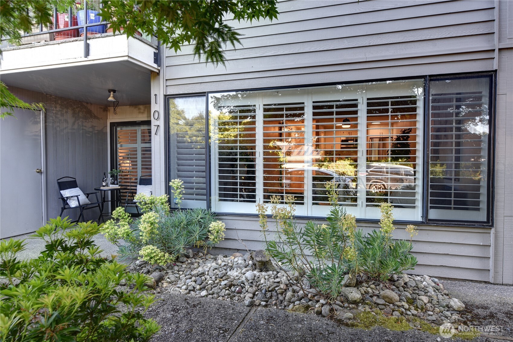 Welcome home to this beautifully updated Magnolia condo that lives more like a private residence than a traditional condominium. Situated on the ground floor, this inviting home offers seamless indoor-outdoor living with a spacious private covered patio, perfect for morning coffee, container gardening, or relaxing year-round. Inside, you'll find an open-concept layout featuring updated appliances, flooring, fresh paint, and custom blinds. The bright living and dining areas flow effortlessly into the kitchen, creating a comfortable space for both everyday living and entertaining. The spacious bedroom offers direct access to the patio, extending your living space outdoors. A hidden door reveals the in-unit washer and dryer, while three oversized closets provide exceptional storage rarely found in a one-bedroom home. Enjoy community amenities including an outdoor pool, fitness room and clubhouse. Includes a dedicated parking spot, and two deeded storage units. Conveniently located near Magnolia Village, Discovery Park, transit, downtown Seattle, and neighborhood shops and restaurants, this is an exceptional opportunity to enjoy one of Seattle's most desirable neighborhoods at an approachable price point. Pre-inspected and move-in ready!