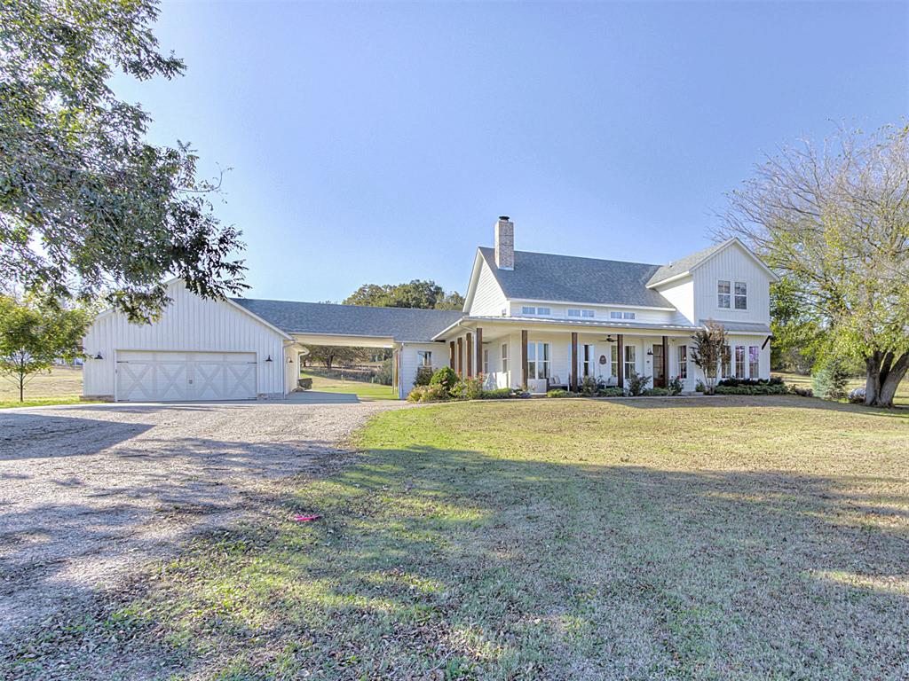 Start your day where 72nd Ave ends in this modern farmhouse built by a long-time Norman builder in 2016 and nestled on 5.25 acres. The dead-end location eliminates through traffic, creating a secluded sanctuary just 7 miles from the University North Park shopping area.The welcoming wrap-around porch spans the front of the house, offering a relaxing outdoor living space with cedar beams that contrast beautifully with the white siding. Step inside and your eye is immediately drawn upward to soaring vaulted ceilings articulated with exposed wood beams. Large picture windows topped with transoms flood the great room with natural light throughout the day, while light-stained solid hickory flooring—prized for its exceptional durability—gives the space a warmth that only wood can provide.  The floor-to-ceiling fireplace serves as a striking focal point, combining rustic whitewashed brick with the clean lines of horizontal shiplap. The kitchen has an expansive island with seating, white shaker cabinets, subway tile backsplash, stainless steel appliances, built-in gas cooktop, and a large walk-in pantry. There's room enough for both a large dining table and breakfast table.The master bedroom features a cathedral ceiling that creates an open, airy feel, with double French doors opening onto a private patio. The ensuite bathroom includes a jacuzzi tub and separate shower, two separate vanities, a toilet room, and a closet that connects directly with the laundry room—making laundry day effortless.  The flexible floor plan accommodates four bedrooms or three with a study. Two bedrooms upstairs each have their own private vanity and share a toilet and shower between them. The separate guest house (576 sq. ft. not included in 2625 Sq. Ft. measurement for main house) the farmhouse vibe with its own large covered front porch wrapped in grape vines, plus a full kitchen, bathroom, bedroom, and two lofts—perfect for visitors, family, or rental income. OEC Fiber is available!