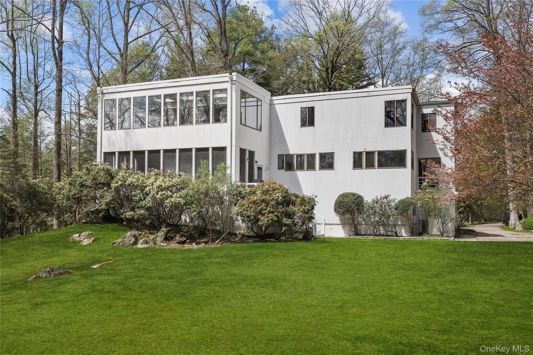 Welcome to this fabulous 4-bedroom, 2.5-bath contemporary Colonial home, perfectly designed for today’s lifestyle with a seamless blend of style and comfort. Set on 2.26 private acres with vast views of the private community lake, this home offers open, luminous living spaces flooded with natural light and thoughtful architectural detail throughout. As you enter the home, you step into the formal living room featuring sliding glass doors to deck, a wood-burning fireplace and floor to ceiling windows that frame the surrounding landscape and bathe the room in sunlight. The formal dining room with balcony provides a large space for entertaining, while the flowing layout ensures effortless movement between spaces. The gourmet eat-in kitchen with center island is steps away from the family room, fireplace, and screened in porch. The primary bedroom suite offers privacy and separate home office with three walls of windows looking over the backyard and lake. Three additional bedrooms and full bathroom complete the second floor. The large private property is ideal for fun outdoor activities, stroll to the lake to kayak or quiet evenings at home. There is more to enjoy when you live in Chappaqua, from the award winning school district, dining in town, convenient metro-north trains, and preserve hiking trails. We have it all for you!