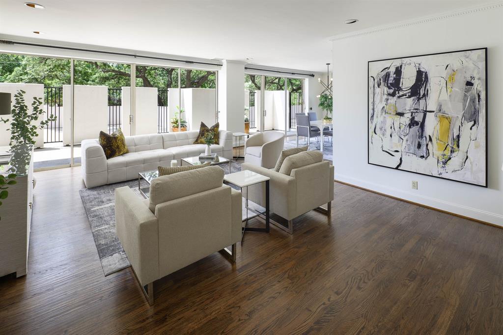 One of the few terrace-floor residences in the iconic Gold Crest Condominiums, this exceptional home combines significant mid-century architecture with an extraordinary indoor-outdoor lifestyle. Gold Crest was designed by George L. Dahl, one of the most influential figures in Dallas architecture and chief architect for the transformation of Fair Park for the 1936 Texas Centennial Exposition. Signature features include floor-to-ceiling windows, views of Downtown Dallas and expansive wraparound terraces providing more than 760 sf of outdoor living & entertaining space. Surrounded by mature trees, the terraces create a private, garden-like setting. An elegant foyer offers views through the home to the outdoors. The living and dining rooms, kitchen and all three bedrooms enjoy direct terrace access, creating a remarkable connection between interior and exterior spaces. A private terrace gate provides direct access to the building's pool area—a rare feature of the terrace-floor lifestyle. The oversized living room offers generous space for multiple seating areas and opens to the dining room. The eat-in kitchen includes a separate breakfast area. The spacious primary suite features two walk-in closets and bath with separate tub and shower and dual vanities. Each secondary bedroom has a private bath. Originally designed with approximately 54 residences, some of which have been combined over the years, Gold Crest offers an intimate, low-density residential experience. Amenities include 24 hour concierge and security, doorman and valet service, pool and outdoor entertaining areas, fitness facilities, guest-suite accommodations, storage and garage parking. George L. Dahl himself chose to live at Gold Crest and remained a resident for the rest of his life. Expansive walls of glass, private pool access and a garden-like setting, this home is a winner, with electricty, water & trash included in the HOA!