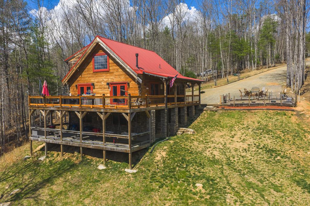 Custom hand-hewn log cabin constructed in 2018 on 6.82 private acres with 300+ feet of frontage on Big Reed Island Creek. This 3 bedroom, 3 bath home offers quality craftsmanship and a beautiful setting just a short drive from Hillsville VA. Main level features an open floor plan with vaulted ceilings, spacious primary suite, and a custom rock wall shower. Loft area includes 2 bedrooms, full bath, and office space. Full basement provides additional bath, laundry, and utility area. A 2 story deck creates excellent outdoor living space for entertaining and enjoying the creekside setting. Property also includes fenced garden area, detached barn/garage with concrete slab floor, fenced livestock area, chicken coop, and cleared road to the water frontage. Access is by private shared drive with recorded road maintenance agreement. Large portion of home furnishings will convey. A opportunity to own a well-appointed waterfront mountain property.
