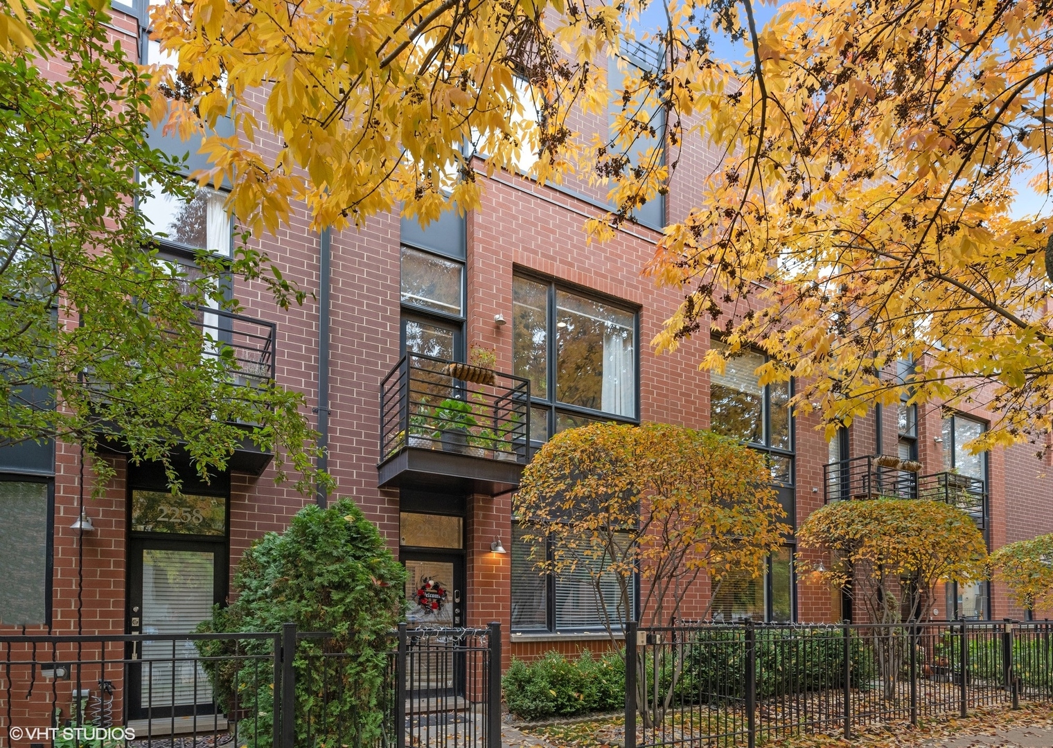 This stunning townhome offers the comfort and feel of a single-family home, set among the city's finest riverfront developments. Enter through a charming gated front yard into a spacious foyer. Next to the foyer is the 3rd bedroom/office space, a great WFH option, and a two-car garage.  Upstairs to the main level boasts a gourmet kitchen with stainless steel appliances, an island, soaring ceilings, and a gas fireplace in the open-concept living and dining area, complete with a balcony ideal for grilling. A convenient half bath and side-by-side washer/dryer are also located on this level.  Upstairs, the luxurious primary ensuite features a double vanity, soaking tub, and separate shower. A generously sized second bedroom and a beautifully finished full bathroom complete the second floor. The top floor features a private rooftop deck with new composite decking, providing an expansive outdoor retreat ideal for relaxation or entertaining.  Enjoy nearby amenities like the River Walk Park, Roscoe Village, Hamlin Park, Logan Square, Mariano's, and a variety of shops and restaurants. With easy access to the highway, this home truly has it all.