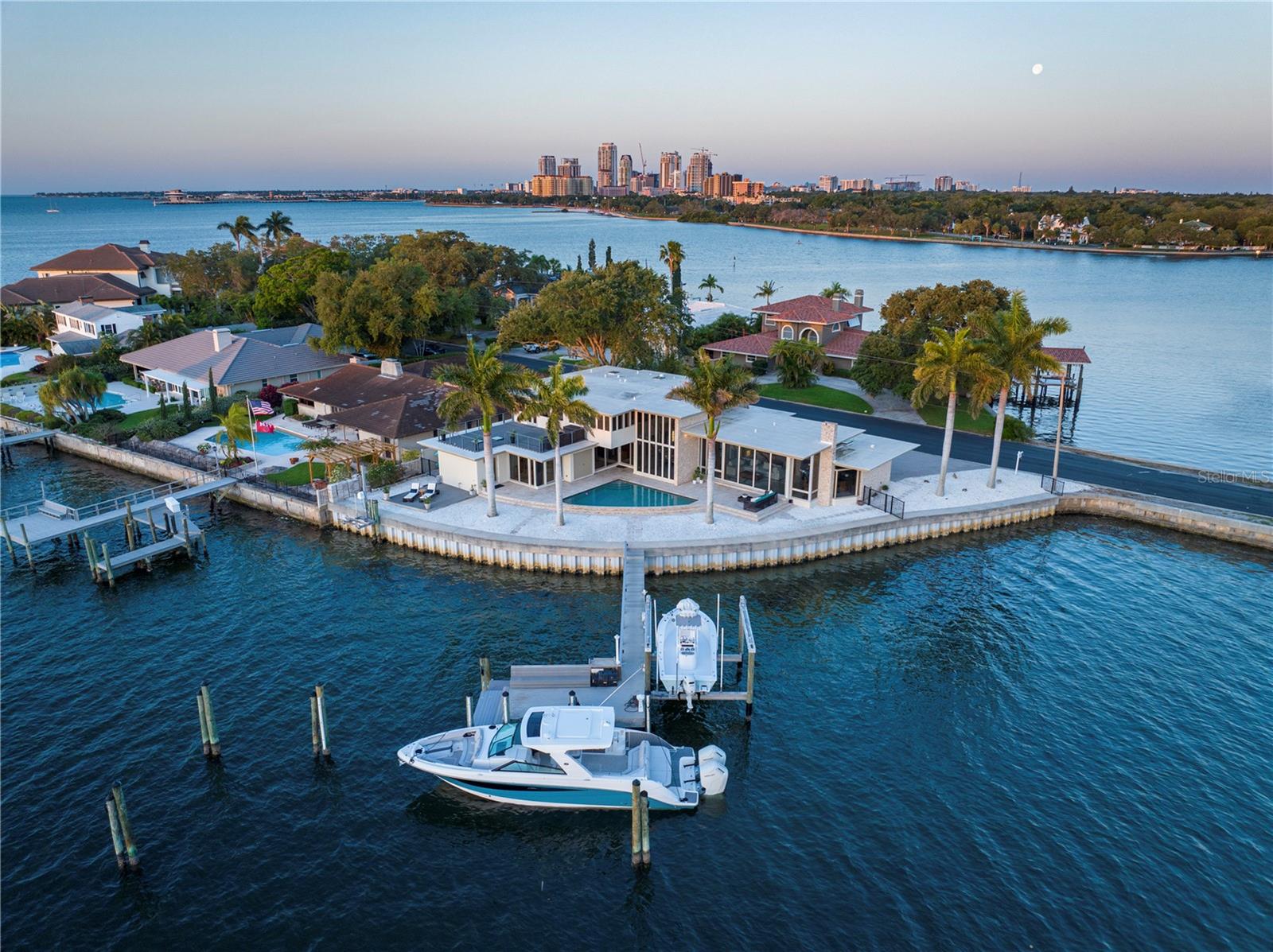 ARCHITECTURAL MASTERPIECE WITH PROTECTED WATERFRONT ON EXCLUSIVE BRIGHTWATERS CIRCLE Designed by Sanford Goldman, protégé of Frank Lloyd Wright, and recommissioned in 2011 to modern standards, this 4-bedroom, 5-bathroom mid-century modern estate is one of only ten homes on the prestigious Brightwaters Circle—widely regarded as one of the most exclusive streets in Tampa Bay. Set on 191 feet of protected waterfront, the residence offers direct access to Tampa Bay and did not take on water during last year’s storms, providing peace of mind alongside its stunning setting. Spanning over 4,300 square feet, the home is a showcase of organic modernism, blending stacked stone, longleaf yellow pine paneling, and imported stone floors with walls of impact-rated glass framing panoramic views. The chef’s kitchen features Wolf appliances and custom cabinetry, seamlessly connecting to expansive living and dining areas anchored by a dual-sided stone fireplace and dramatic wood ceilings. The primary suite offers bayfront views, a rooftop terrace, and a spa-inspired bath, while each guest suite includes its own en-suite bath and tranquil design details. Outdoor living is equally refined, with a heated pool, manicured landscaping, and a deepwater dock with 20,000-lb lift, 50-amp power, and freshwater hookup accommodating yachts up to 80 feet. Positioned on a quiet cul-de-sac just minutes from downtown St. Petersburg, this estate represents the rare convergence of architectural pedigree, modern resilience, and one of the finest waterfront locations in Tampa Bay