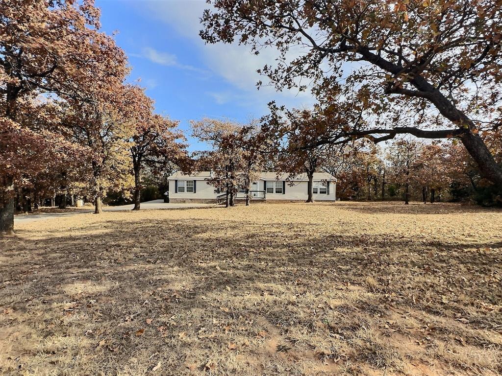 Set on a sprawling 1-acre corner lot framed by mature oak trees, this one-owner home offers peaceful living in the quiet Forest Fox community. Thoughtfully designed with a 3-bedroom split plan and 2 full bathrooms, the home blends comfort, functionality, and plenty of outdoor charm. Enjoy low-maintenance upgrades including Trex decking on both the front porch and covered back porch, brick skirting, an extended driveway with additional parking, an invisible pet fence, and a storm shelter for peace of mind. Inside, the spacious layout is perfect for entertaining. The large living room features a never-used fireplace and a convenient pass-through with bar seating that opens to the kitchen. You'll appreciate the dedicated dining space, abundant storage closets, generous kitchen cabinetry, and pantry. The laundry room includes a secondary exterior door for easy backyard access. All bedrooms offer walk-in closets, and the private primary suite includes dual vanities, a large corner shower, and a relaxing soaking tub. This property is ready for its next chapter and your cosmetic touches!