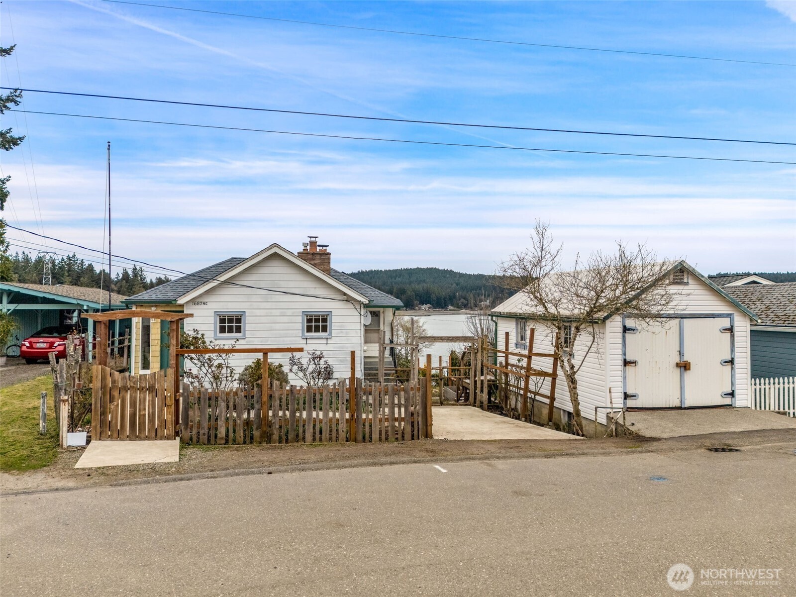 Rare Liberty Bay waterfront opportunity in the charming waterfront community of Keyport, WA with 60’ of medium-bank shoreline, private stairs with concrete treads to the water, with room to beach your kayaks and have ready access to your beach chairs.  You can see all the way down Liberty Bay to Poulsbo from the top of the beach stairs.  This 1934 home offers outstanding potential for renovation or reimagining in a highly desirable Keyport setting.Enjoy north and easterly views across Liberty Bay with large water views from the living room, kitchen and view decks. Main level includes 2 bedrooms and 1 bath, while the daylight basement offers additional finished space including water view bedroom with 2nd fireplace, office,  ½ bath, utility room and shop space.  It even has fiber internet with a variety of ISP providers for speed and performance options.Major systems already addressed with newer roof and updated gas furnace and water heater (2020). Composite decks enhance outdoor living. Detached garage with equal storage space below.Home is solid but mostly original and ready for updates—perfect for investors, builders, or buyers looking to build equity in a waterfront setting.  Cash or conventional financing.