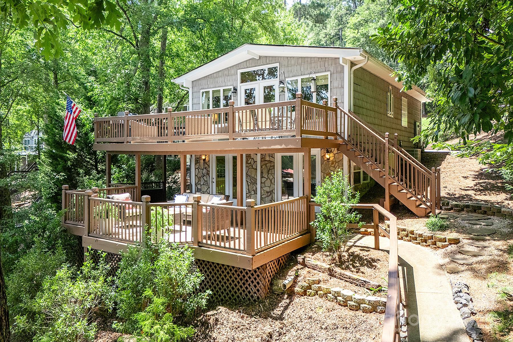 Location, Location, Location!! One of a kind! This rare waterfront gem on Lake Tillery is being sold furnished! Amazing open floor plan with lots of glass overlooking the lake. At the heart of the home is a stunning great room with cathedral ceilings, a beautiful rock fireplace, and walls of glass that flood the space with natural light. The kitchen shines with custom cabinetry, granite countertops, a spacious breakfast bar, and generous prep space. The main level primary suite feathers vaulted ceilings, a walk-in closet and a spa like bath with a jetted tub and separate shower. A convenient half bath is also located on the main. The lower level offers a large den with built-in bunk beds, a guest bedroom, bonus room and full bath- ideal for hosting. Outside, enjoy mature landscaping, multiple covered and uncovered decking and porches. A picturesque sidewalk leading to the oversized two slip boathouse and expansive open decking perfect for sunning, swimming, and soaking in the view.