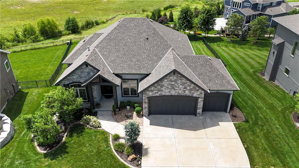 This stunning former model home is loaded with high-end upgrades and designed for effortless living. Featuring an open-concept main floor, the Great Room seamlessly flows into the kitchen, which includes a staying refrigerator and a genius grocery load door directly from the garage. Arched ceiling treatments in the Great Room; Dining Room, and Primary Bedroom.Step outside to your private oasis: a large, fenced backyard with concrete-edged landscaping and a covered, screened-in deck featuring its own fireplace and TV setup.Standout Features:Entertainment Ready: Built-in speakers (Kitchen, Basement, Deck) w/ amplifier included.Bonus Space: Massive suspended-slab storage room under the garage + a dedicated workout room.Efficiency: High-efficiency HVAC system and custom stair lighting.Unbeatable HOA Amenities:Live like you're on vacation! Access a 65-acre stocked lake with a boat ramp, 2 saltwater pools, 4 lighted tennis courts, sand volleyball, and walking trails. The massive 2-story clubhouse features an indoor basketball court, saunas, a gym, and year-round community events. Sellers have added the following; Back Yard Fence; Epoxy Garage Floor; Concrete Landscape Border; Exercise Room; Garage Door Openers; Large Entertainment Center in the lower level; Audio System w/Ceiling speakers!!!Schedule your tour today to see this Olathe gem in person!