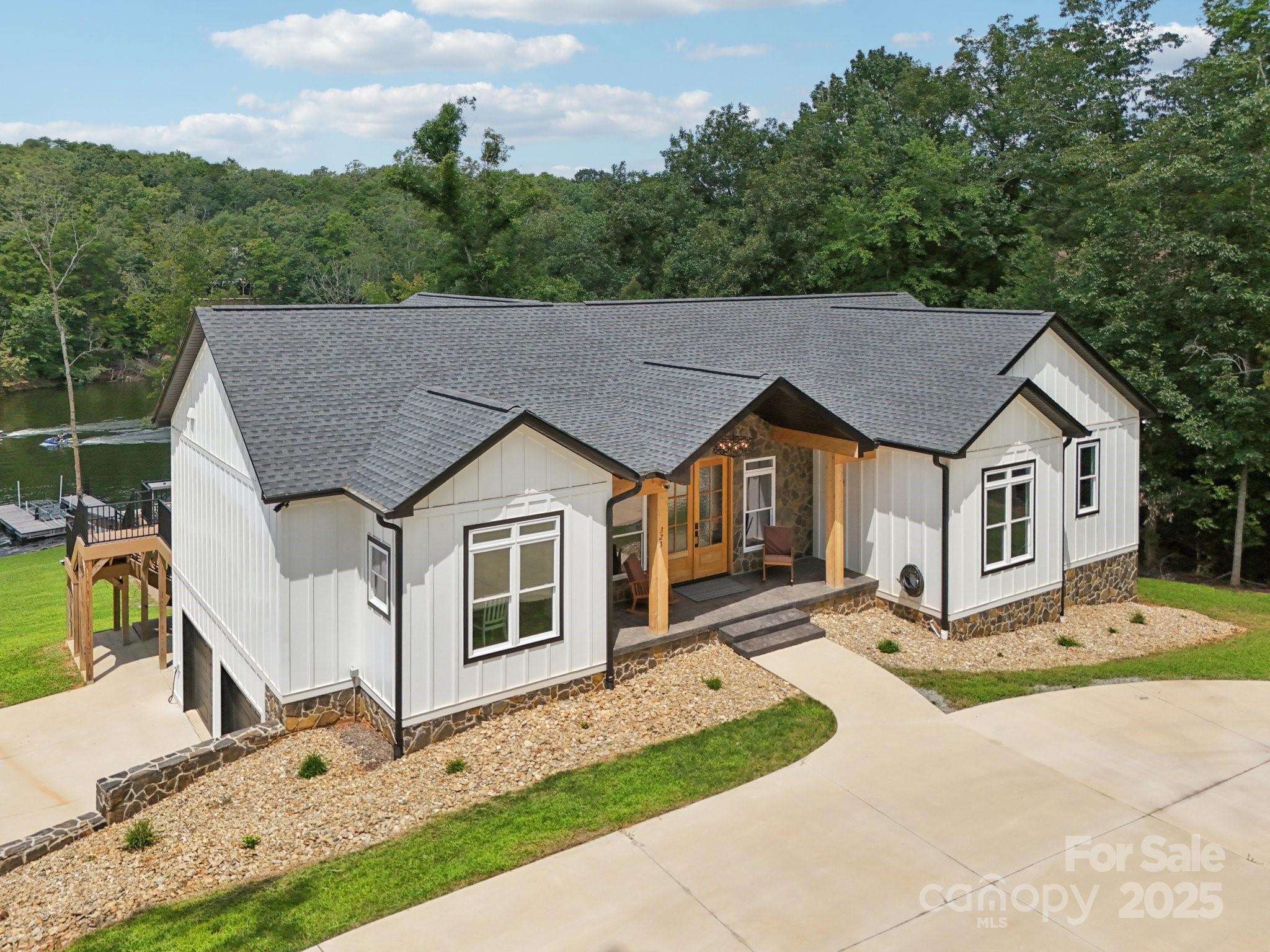 Move-in Ready – Furnished Waterfront Retreat on Badin Lake! This stunning 4BR/3.5BA home is tucked away in a secluded cove within the gated Heron Bay community, offering trails, a clubhouse, and a boat ramp. Designed for entertaining, the open floor plan features a NanaWall folding glass door that seamlessly blends the great room with the screened deck for indoor-outdoor living. The primary suite offers serene lake views, deck access, dual walk-in closets, and an en-suite bathroom. The walk-out basement adds a spacious family room and would also make a great recreation room with French doors to a covered patio. Both patio and deck overlook a gently sloping path to the water and private floating dock with boat lift, and jet ski port—perfect for endless lake days. Quality finishes include Hardie board and batten siding, a stone fireplace, granite countertops in the kitchen and full baths, and European Oak engineered hardwood flooring. Additional highlights include a circle driveway with ample parking and a basement-level 2-car garage. Convenient to Charlotte, Greensboro, and Winston-Salem, with Uwharrie National Forest just 16 miles away, this fully furnished home is ready for you to move in and start enjoying lake life immediately.