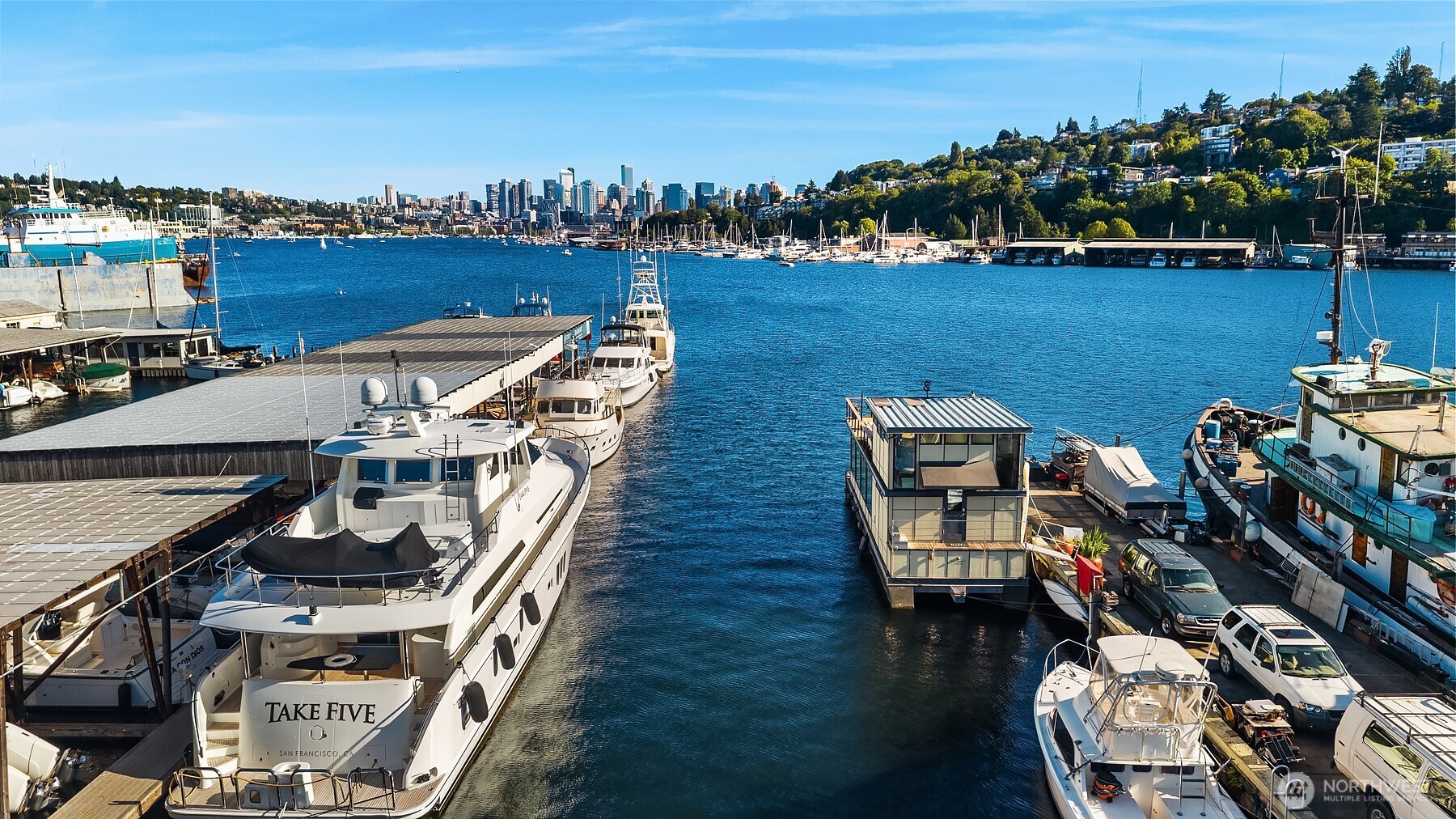 Experience waterfront living at its finest in this beautiful houseboat. Thoughtfully designed layout w/ dedicated office perfect for remote work/creative pursuits (or large walk in closet!)& expansive open-concept living & kitchen for entertaining or relaxing. Gorgeous Teak floors throughout and lots of clever storage! Large windows flood interior w/ natural light & create a seamless connection to water & landscape beyond. Roll-up wall opens to the lake, creating an effortless indoor-outdoor living experience. Step directly onto the waterside deck & enjoy morning coffee, evening sunsets, or passing boats and seasonal wildlife.  Upper-level bedroom serves as private retreat complete w/ direct access to a generous rooftop-style deck. Whether you're taking in city lights at night, watching the sunrise, or simply enjoying the fresh air, this elevated outdoor space provides an exceptional vantage point. Whether you're seeking a full-time residence, weekend getaway, or unique waterfront lifestyle, this exceptional houseboat delivers unmatched quality, abundant outdoor living spaces, & tranquility of life on the water while remaining close to amenities of the city.