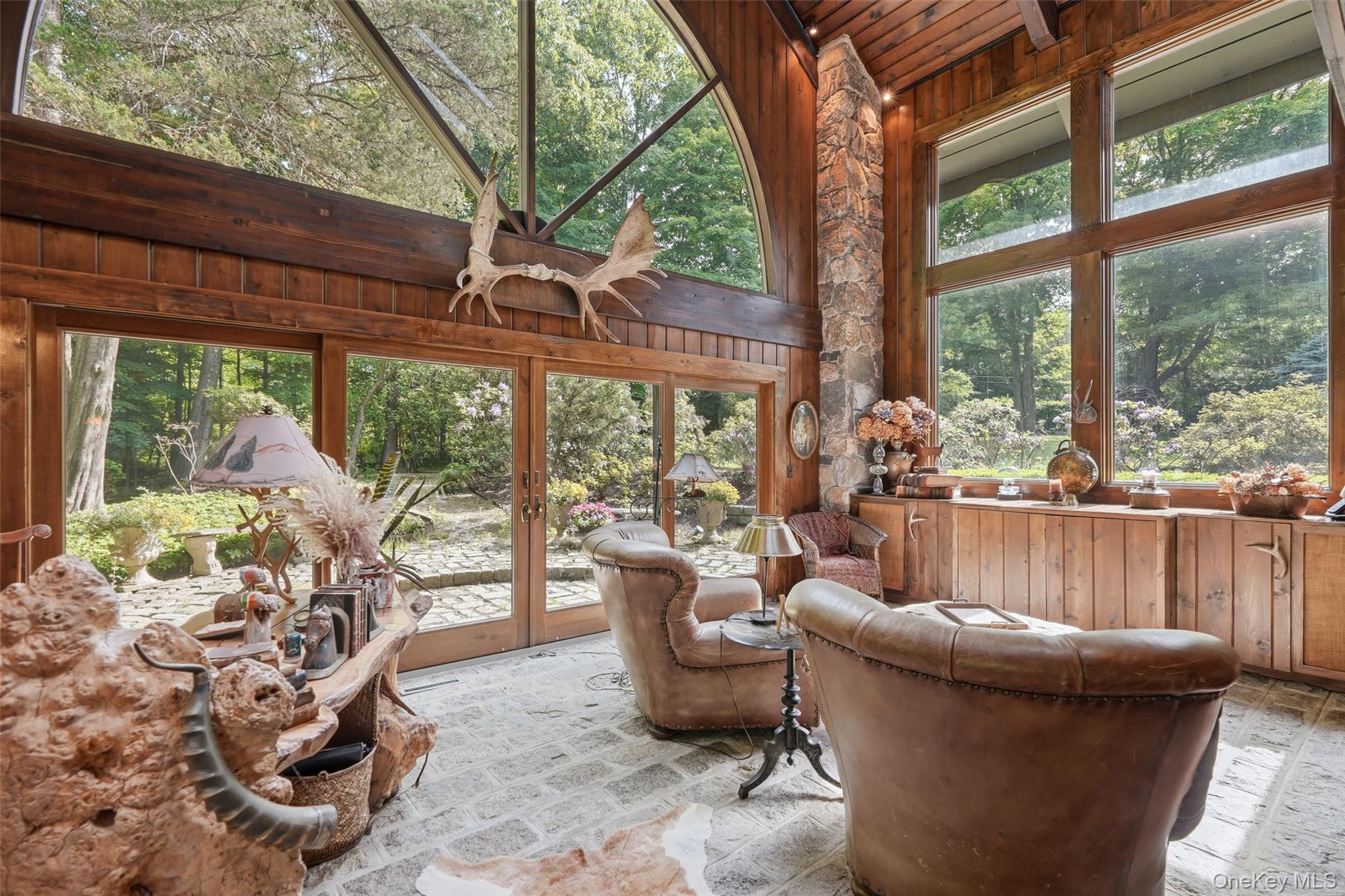 This one-of-a-kind 5 bedroom, 5 full bathroom rustic California inspired residence on one of the toniest roads in Pound Ridge sits on 6.5 private acres, complete with a pool, tennis court and treehouse. Situated in a resort like setting, the home's exquisite indoor-outdoor flow and abundant natural materials, you'll feel worlds away, but is just 3 minutes from town and an hour from NYC. Once owned by Ted Sorenson, JFK's speechwriter, the unique estate is ideal as a year-round home, weekend retreat or secluded hideaway with Belgian block and chestnut floors, stone columns (the stone of which was excavated from the site), tongue-in-groove cedar walls, soaring beamed ceilings, 22 skylights and custom windows. Custom stair railings designed by renowned rustic artist, Daniel Mack. Enjoy lavish entertaining in impressive living spaces with floor-to-ceiling fireplace and windows. The rustic dining room seats 16, the masterful kitchen with original copper bar counter, accommodates gatherings of any size. Upper-level primary suite, main-floor two-bedroom suite, home gym, media room, sauna and office with custom desk made of one solid piece of hundreds of years old Baobab tree. The lower level en suite bunk room provides ample accommodations, with private entrance. Resort-like grounds and a bucolic location make this an exceptional country estate. Custom, high level properties like this don't come up very often.
