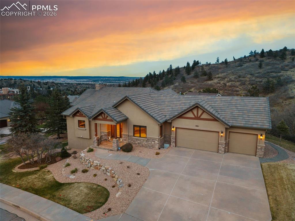 Experience elevated Colorado living in this exceptional luxury ranch home nestled in the highly sought-after Peregrine neighborhood. Perfectly positioned on over half an acre of flat, usable land, this residence captures breathtaking views of Blodgett Peak while offering an ideal blend of elegance, comfort, & functionality. The home’s grand presence is undeniable with its timeless stucco exterior, tile roof, & oversized 3-car garage. Inside, soaring floor-to-ceiling windows frame the stunning mountain scenery & flood the home w/ an abundance of natural light. Knotty alder doors & trim throughout add warmth & sophistication, complementing the thoughtfully designed functional floorplan. The gourmet kitchen is designed for both everyday living and entertaining, featuring stainless steel appliances, a large center island, breakfast bar seating, walk-in pantry, abundant cabinetry, and a sunny dining nook. A formal dining room provides the perfect setting for hosting gatherings, while multiple decks and patios seamlessly extend the living spaces outdoors. The luxurious primary suite serves as a private retreat w/ access to a private deck overlooking the spectacular views. The adjoining spa-inspired 5-piece bath, huge walk-in closet, & convenient connection to the main level laundry room for convenience. A dedicated main level office offers an ideal work-from-home space. The walk-out basement is an entertainer’s dream, featuring a spacious theatre room, wet bar, & a custom wine rack closet perfect for showcasing your collection. The lower level offers exceptional flexibility with a junior suite ideal for guests, as well as a Jack & Jill bedroom layout connected by a full bath. Enjoy Colorado outdoor living at its finest with two patios, two decks, & close proximity to the Blodgett Open Space for hiking & recreation. Located in the award-winning Academy District 20, this remarkable property offers luxury, lifestyle, & one of the most coveted settings in Colorado Springs.