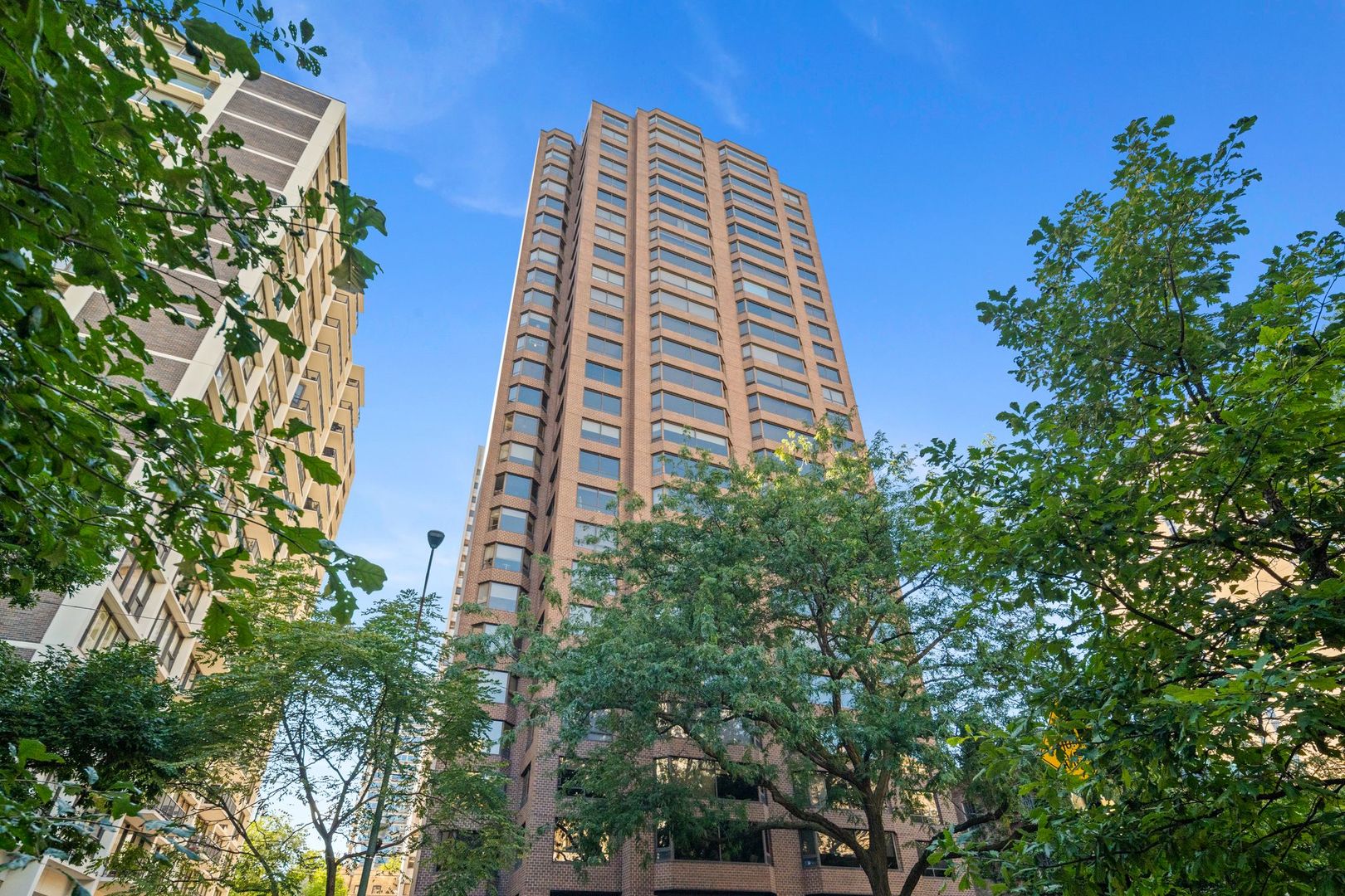 This exceptional 10th-floor unit in the Gold Coast neighborhood embodies modern elegance. With 3 bedrooms and 2.5 bathrooms, it features an open floor plan, hardwood floors throughout, and oversized windows offering South, East, and West exposures. The kitchen is a highlight, showcasing custom cabinets, high-end stainless steel appliances (including a wine fridge), granite countertops, and a stylish backsplash. The primary bedroom includes an en-suite bath with dual sinks and a large walk-in closet. The two additional bedrooms are bathed in natural light and offer ample storage space. Custom built-ins enhance the unit's functionality and style. Residents enjoy a range of amenities, including valet parking and an exercise facility. Plus, you're just a short walk from numerous shops, restaurants, and the lake, making this an ideal location for urban living.