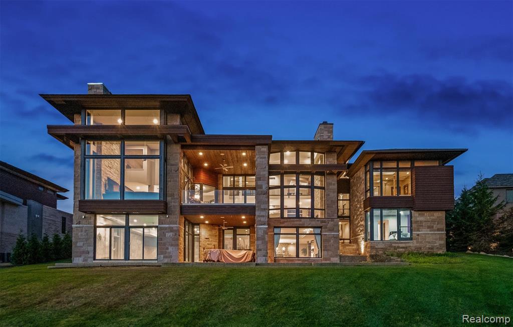 A true architectural statement by AZD Architects, this striking contemporary estate is perfectly positioned within the exclusive, gated Turtle Lake community on a premier 1.15-acre lot with coveted southern exposure. Walls of glass in the soaring two-story great room, intimate sitting areas, and expansive covered lanai frame uninterrupted views of Turtle Lake—capturing every moment from sunrise to sunset. At the heart of the home, a sleek, state-of-the-art kitchen with premium Thermador appliances connects seamlessly to a hidden chef’s kitchen, creating the ultimate setting for both everyday living and sophisticated entertaining. The private primary suite spans its own level, offering a sanctuary of peace with dramatic lake vistas and a spa-inspired bath defined by minimalist elegance. Designed with intention, the residence integrates geothermal heating, radiant heated floors, and a full Control4 smart home system for effortless modern living. The resort-style walkout lower level delivers every indulgence—an indoor freshwater pool, golf simulator, home theater, and generous lounge space. Outdoors, tranquil grounds flow to a private dock crafted for a 25-foot electric pontoon, while low-maintenance landscaping underscores the clean lines of the architecture. An oversized four-car garage with drive-through bay and expansive motor court provide daily convenience, completing this rare offering. More than a home, this is a refined lakefront sanctuary in one of Bloomfield Hills’ most prestigious enclaves. BATVAI