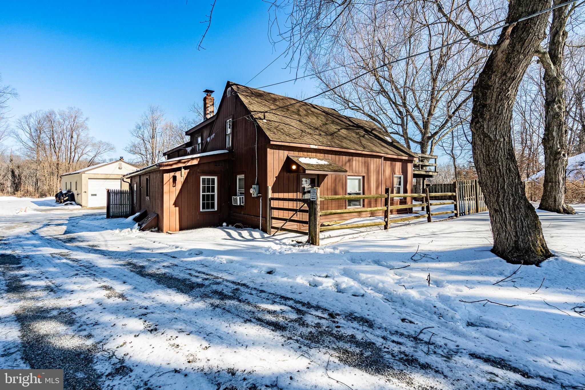 Nestled on a peaceful one-acre lot in West Chester this charming 3 bedroom, 2 full bathroom Cape Cod home (with a MASSIVE detached garage) exudes timeless character ready for you to make it your own!  Entering the home from a long private driveway that leads to a lot that fits 5+ vehicles, you will see the home that sits forefront and conveniently close to the garage space in the rear. Inside, the home exudes cozy character, highlighted by exposed wooden beams that add rustic elegance and a sense of history throughout key living spaces.The standout family room is exceptionally charming and cozy, with a  pellet stove that provides efficient, flickering warmth on chilly evenings like these! —perfect for gathering with loved ones. The room's thoughtful design creates an intimate, lived-in atmosphere ideal for relaxing or entertaining.A unique pair of spiral staircase adds a touch of whimsy and architectural interest, each one gracefully connecting the main level to the 2 second story private bedrooms while saving space and enhancing the home's distinctive personality (1 bedroom in on the first stroy).  To the side stands an impressive, one of a kind, 1377-square-foot detached garage, a true standout with its soaring 14-foot ceilings that create an airy, versatile workspace perfect for accommodating a car lift, woodworking shop, classic car restoration, landscaping or almost any large-scale hobby. Fully equipped with electrical throughout, dedicated office space, reliable heating, and a half bathroom, the building functions as much more than storage—it's a practical retreat that offers connivence and ease.  Together, the property offers a rare blend of historic charm and modern utility, all spread across generous acreage that feels worlds away from the bustle yet remains conveniently close to West Chester's vibrant downtown.