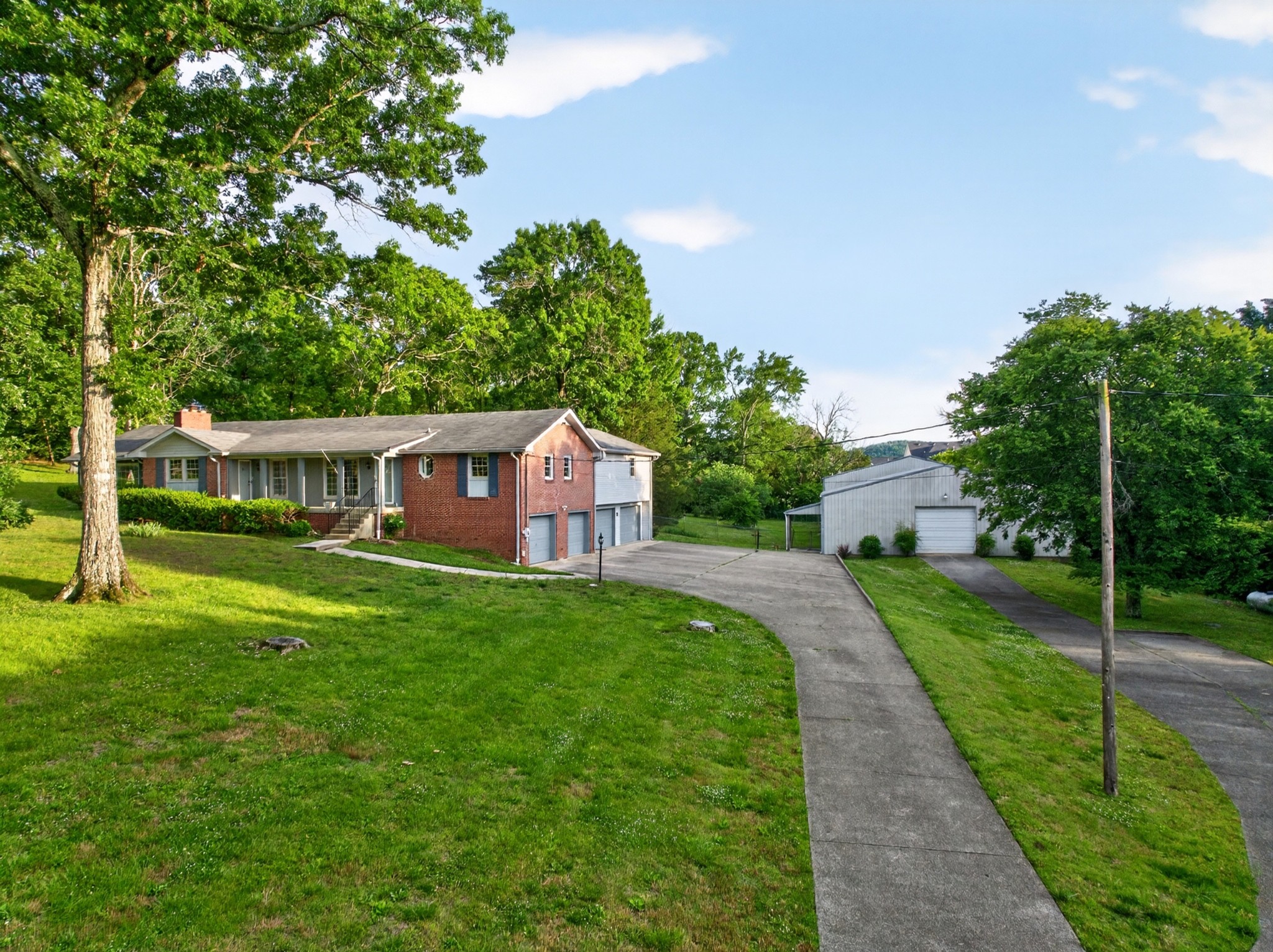Price Improvement! Rare Nolensville acreage with space, flexibility and utility that almost never hits the market this close to town. Set on 3.52 private acres beside Annecy, this one-of-a-kind property offers 3,400+ sq ft of living space, a 4-car garage, and a massive 7,600 sq ft heated outbuilding measuring approximately 152' x 50'. Previously used to house a large car collection—with another section set up as an indoor pickleball court—the building features electricity, heat via a 100-gallon propane tank, concrete floors and tremendous potential for collectors, hobbyists, tradespeople, entrepreneurs or business use.The home itself is full of character and opportunity. Buyers who want something more interesting than a cookie-cutter subdivision home will appreciate the generous footprint, 4 bedrooms, an oversized primary suite & a large Florida room just off the primary bedroom. A past expansion added a 26x20 cabin-inspired den with fireplace that opens to a covered deck, creating a warm gathering space with a retreat feel. The basement adds approximately 500 sq ft of partially finished living area plus room for workshop space, storage and parking.Adding even more upside, the property is now connected to sewer—an important improvement that may open the door for future updates, expansion or reimagining. The setting offers practical advantages in a no-HOA/no known restrictions property just outside town limits, including flexibility, breathing room & a lower county-only tax profile while still being minutes from Nolensville Road, local restaurants & the heart of town.Zoned for sought-after Williamson County schools: Nolensville Elementary, Mill Creek Middle and Nolensville High. Nearby growth continues to enhance the lifestyle value, with the planned Nolensville Town Square, the Publix-anchored Village Green center now open, & a Kroger Marketplace on the way. Rare acreage, serious garage/barn space & a highly convenient Nolensville location. Buyer to verify uses.