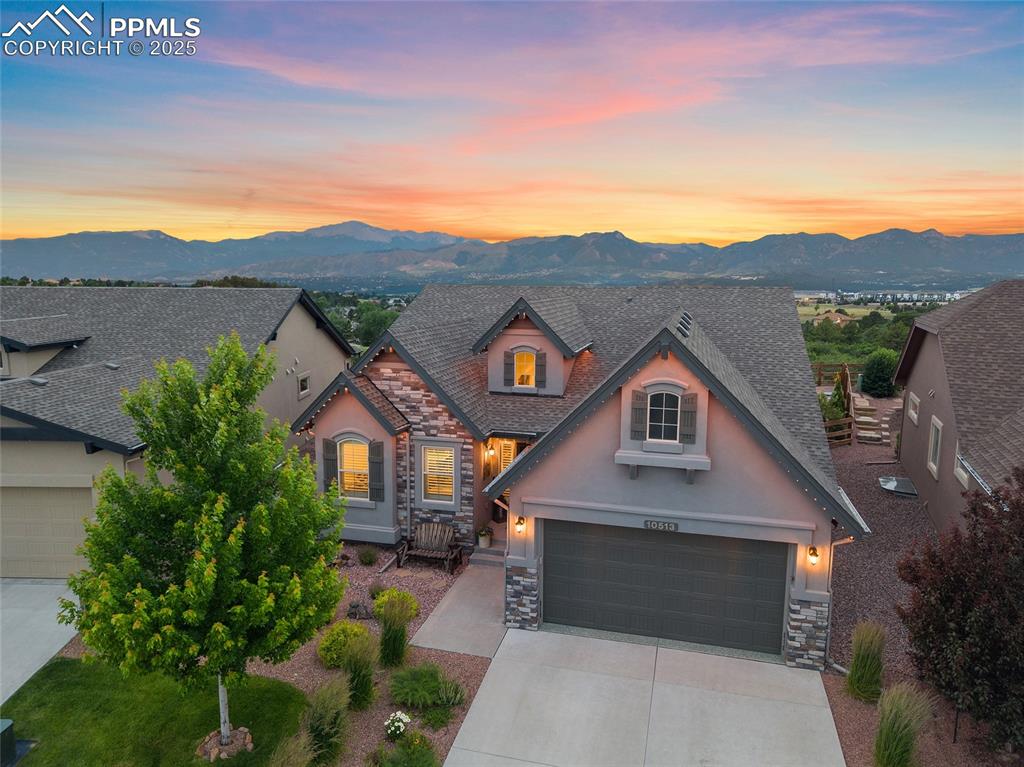 Tucked inside a sought-after gated community, this stunning ranch home is packed with features that make it stand out from the crowd. To start with, the mountain views are absolutely breathtaking. Step inside to soaring ceilings, natural light, and a cozy stone fireplace framed by picture windows that showcase Pikes Peak like a postcard. Hardwood floors run throughout the main level, adding warmth and elegance to every space. The open layout flows into a beautiful kitchen with quartz counters, double ovens, a gas range, custom cabinetry, and a generous pantry. It’s the kind of space that makes everyday moments feel special. The main level also features a spacious primary suite where you can wake up to mountain views and step out to your private patio. The en suite bath includes a tiled shower with dual shower heads, dual vanity, and a walk-in closet that connects to the laundry room for everyday ease. You'll also find a second bedroom, full guest bath, and a dedicated dining area that completes the main level. With mountain views through every window and sunlight pouring in, this space is made for connection. Sliding doors open to the patio with retractable awning creating effortless indoor-outdoor flow for morning coffee, sunset dinners, and everything in between. Soak in the hot tub, gather around the fire pit, or relax on one of the multiple patios surrounded by professional landscaping and low-maintenance turf. Jellyfish soffit lighting adds the perfect glow, from warm ambiance to festive sparkle. Downstairs, the finished basement brings all the fun with a spacious family room, theater seating, surround sound, wet bar with beetle kill custom pine walls, upgraded carpet and pad, full bathroom, and two additional bedrooms. There’s even an under-the-stairs fort that’s every kid’s dream hideaway. The oversized garage is insulated and heated, with a four-foot extension and sleek epoxy floors. Sophisticated living framed by unforgettable Colorado views