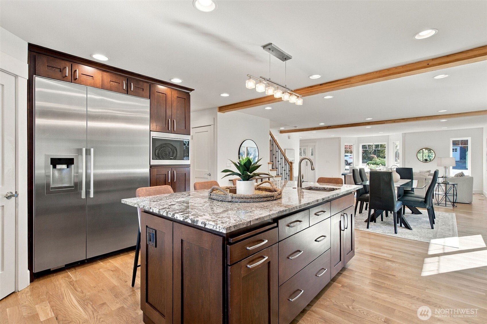 A stainless refrigerator and wall oven finish the kitchen, which opens to the living and dining spaces.