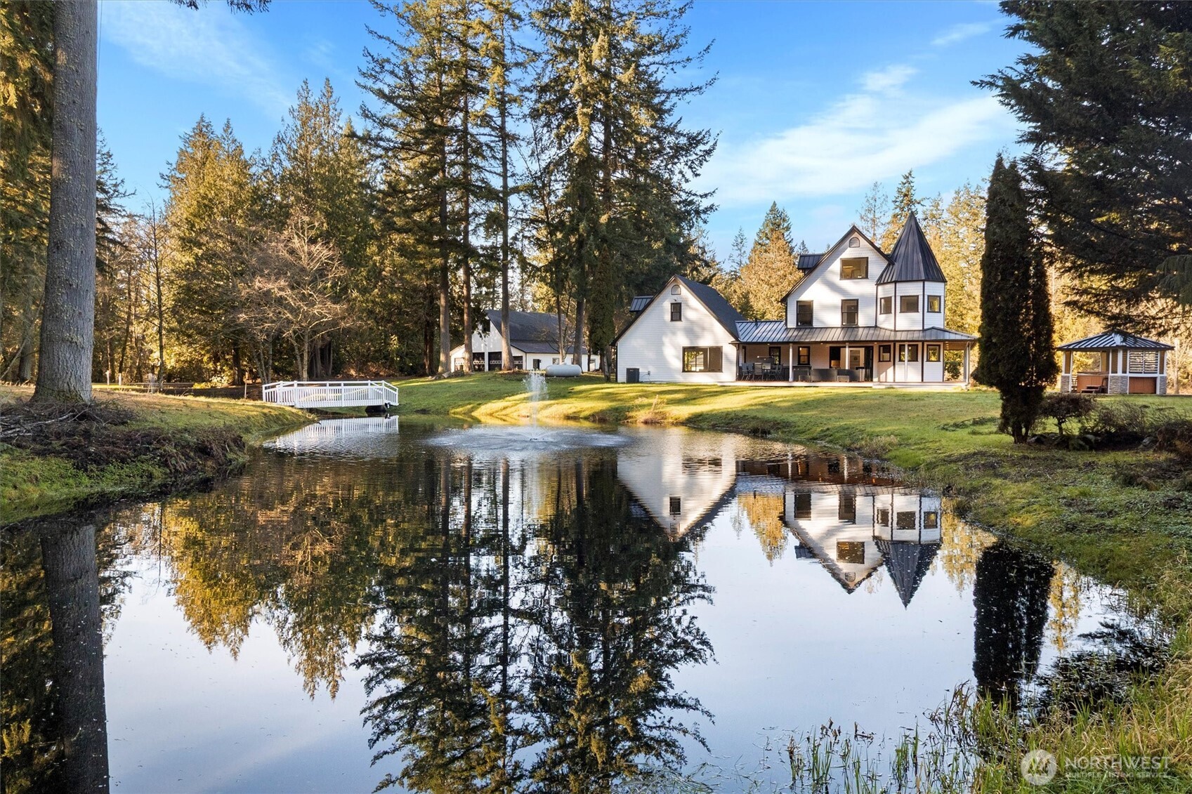 Remodeled Storybook Craftsman with high-end finishes and original refinished hardwoods throughout. Features a new roof with metal accents & skylight balconies overlooking Mt Baker, pond & surrounded by park-like setting. Heated tile floors, mood lighting, and a chef’s kitchen with Forno appliances, custom wine bar, and 8-ft accordion doors to a large deck and outdoor kitchen. Two luxe en-suites with soaking tubs overlook a pond with fountains. Top-level suite includes 5 closets, skylight balcony, and smart glass door. Media room with acoustic paneling, flex space with kitchenette and ¾ bath. 2,800 SQFT shop with 4 bay doors + loft, detached garage with gym, orchard, hot tub, and gazebo. Wraparound porch on 5 usable acres—ideal for horses or a mini farm. Minutes to I-5 and all amenities!