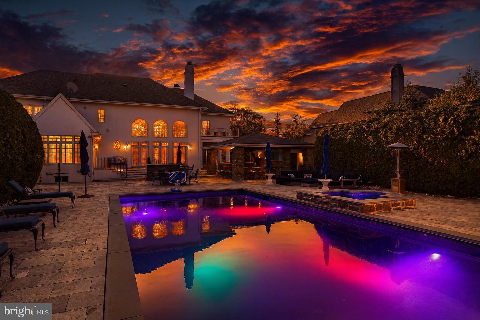 A Masterwork of Refined Living in Prestigious Wayne, PA. Set amid the storied Main Line, this exceptional residence embodies the very finest in East Coast luxury living. Positioned on nearly an acre in the coveted Whitegate enclave, the home offers an impressive 7,640 total square feet of meticulously curated interiors and world-class amenities—creating a sanctuary where sophistication, comfort, and architectural excellence converge.From the moment you arrive, the home’s elevated design reveals itself. Custom Italian Bella Porta Miraquadra Series doors usher you into a world of craftsmanship and impeccable taste. At its heart lies a chef’s kitchen conceived for both culinary artistry and everyday elegance—showcasing executive-grade custom cabinetry, Silestone White Zeus countertops, and a full suite of Sub-Zero, Wolf, and Bosch appliances. A grand 1½-inch butcher-block island stands as the centerpiece, outfitted with a Rohl farmhouse sink, artisan faucets, ambient pendants, a statement chandelier, and luxe details such as an Insta-hot and filtered water system and pot filler. Mosaic glass tilework and custom seating complete this remarkable culinary environment.Entertaining unfolds with ease in the gracious living and dining spaces, each enhanced by bespoke built-ins and designer window treatments. A richly appointed office provides an inspiring setting for work or reflection, while the sun-splashed conservatory offers a peaceful vantage point to take in the home’s serene surroundings. Three fireplaces—including one positioned poolside—infuse the home with warmth, ambiance, and architectural character.The primary suite is a haven of pure indulgence. Custom wardrobe cabinetry, a tailored dressing table, and a private balcony overlooking the pool create an atmosphere of serene elegance. The spa-inspired ensuite bath boasts heated marble floors and a custom steam shower with multi-massage heads—an everyday retreat reminiscent of a boutique luxury spa. Secondary bedrooms continue the home’s elevated aesthetic with dual vanities and exquisitely finished custom showers.For the automobile connoisseur or hobbyist, the property includes an attached 3-car garage paired with an additional two-story, 2-car structure. Outdoors, the estate reveals its resort-style amenities and a series of exquisite upgrades designed for luxurious living and exceptional entertaining. The expansive exterior patio is anchored by Silver Tumbled Travertine paver decking and elevated by Dolce Vita leathered marble counters. Artisanal Vihara Ehex Silk and Falling Star Sleek Ceylon wall tiles create a striking visual backdrop, while a GE Monogram grill and burner, custom built-in fireplace, and integrated pizza oven offer an unrivaled alfresco culinary experience. A sophisticated pool with retractable cover, a well-appointed pool house, and a handcrafted stone bar further enhance the outdoor oasis.Completing the grounds is a private park complete with tennis and basketball courts, a playground, and manicured green space for recreation and relaxation. The heated granite cobblestone driveway adds both elegance and functionality, ensuring a grand approach in every season.The lower level extends the home’s entertaining prowess with a custom bar—enhanced in 2020 with new appliances—a climate-controlled wine cellar, dedicated home gym, and an immersive theater room designed for cinematic experiences.Offering five spacious bedrooms and six luxurious baths, this residence is the epitome of harmonious living. Additional comforts include central air, a stately fireplace, and a thoughtfully planned laundry suite.1053 Whitegate Road stands as a statement of luxury, lifestyle, and legacy—an extraordinary opportunity to acquire one of Wayne’s most distinguished properties in the heart of the Main Line.