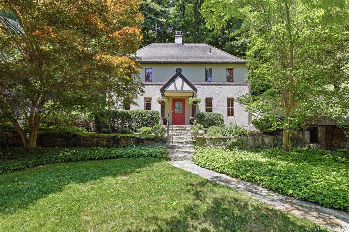 Straight from the pages of a storybook, this enchanting French Revival Tudor-inspired home is tucked amongst a canopy of mature trees and natural stone walls which create an unforgettable first impression. A winding stone walkway leads to a charming covered entry highlighted by a stained glass front door, hinting at the warmth and character that await inside. Living room with fireplace, eat-in kitchen with farm sink, beamed ceilings, and updated appliances with access out to a large terraced patio. Offering three Bedrooms, the primary bedroom/bath provide access to third floor flexible space as office/studio with additional storage. Finished lower level designed for versatility as recreation/media/playroom, complete with powder room, laundry, utilities and garage. Rich in architectural detail and overflowing with charm, this is the kind of home that instantly captures your heart. Award winning Chappaqua school district; 4 minutes to the Chappaqua metro north train station, 46 Min. express to Grand Central, 0.9 miles to town.