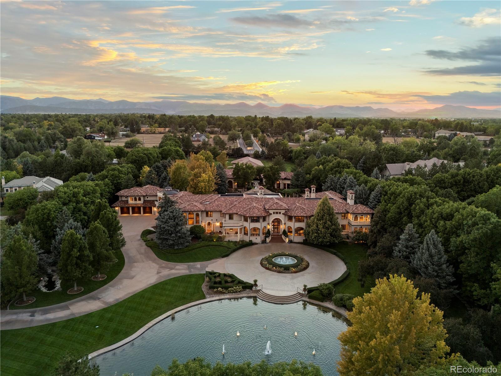 Where coming home feels like getting away. Explore Sognare in full at 6965SPoloRidge.com. Within Littleton's gated Polo Reserve, a second private gate opens to 5.7 fully fenced acres where water, gardens and architecture create a world apart. The arrival unfolds slowly: a living koi pond, fountains, mature trees, then the residence itself. Beyond the front doors, the grand foyer looks through to gardens and water, offering a first glimpse of a life that can unfold almost entirely here. The city stays close; the day no longer revolves around it. The 21,677-square-foot residence has the scale to gather and the intimacy to retreat. Arched glass doors open the soaring, stone-columned great room to covered terraces. Hand-worked iron, natural stone and intricately detailed ceilings bring warmth and individuality to its scale. From the main-level bar, a spiral stair leads to a tasting room and conditioned wine cellar; evenings can continue in the tiered theater or by the fire downstairs. A cherry-paneled study and garden-facing fitness and recovery suite invite quieter pursuits. Upstairs, a secluded primary wing looks over the gardens; other en suite bedrooms and a separately accessed apartment with its own kitchen allow life to move at different rhythms. Outside, a pool courtyard, hot tub, outdoor kitchen, bocce court and fire pit invite afternoons that become evenings. The detached guest house gives visitors a place of their own. A separate professional recording studio offers space to create, while a barn and fenced pasture make room for equestrian pursuits. Seven dedicated garage spaces and enclosed barn storage for approximately six more vehicles accommodate a collection without dominating the estate. What stays with you is not any single feature, but the freedom to choose your day: a quiet morning in the gardens, a house full of friends, or the simple pleasure of closing the gates and keeping it all to yourself.