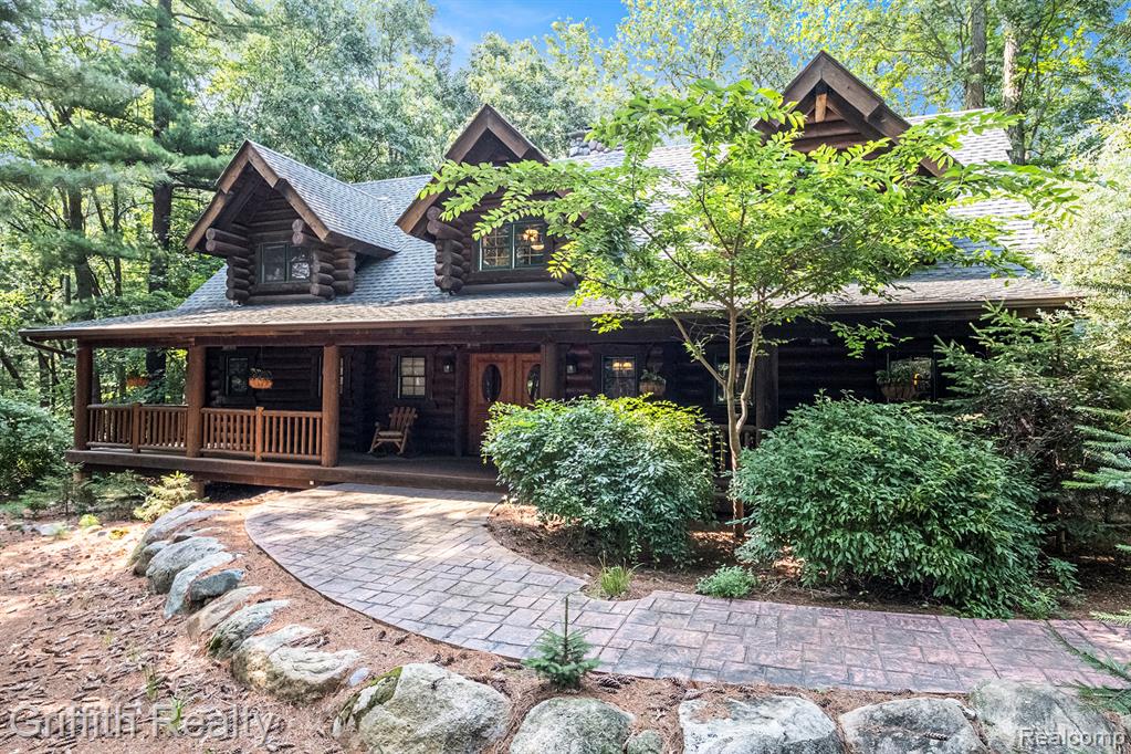 A “Rocky Mountain” log cabin home on almost 2.5 acres surrounded by pines and woods. This beautifully crafted home offers a unique opportunity to enjoy a spacious living room with high ceilings and massive stone fireplace; 2 upstairs bedrooms each with own bath and heated floors; nicely finished basement currently used as gym; theatre and billiard room. You can enjoy the outside of this home by sitting in your rocking chair on the covered front porch or entertaining on your expansive back deck overlooking nature. Oversized 3 car garage finished with drywall ceiling, full logs, epoxy floor and is heated. Large, one bedroom apartment beautifully appointed over the garage, with separate outside entrance! House wired for generator (portable generator negotiable). This is an amazing opportunity!