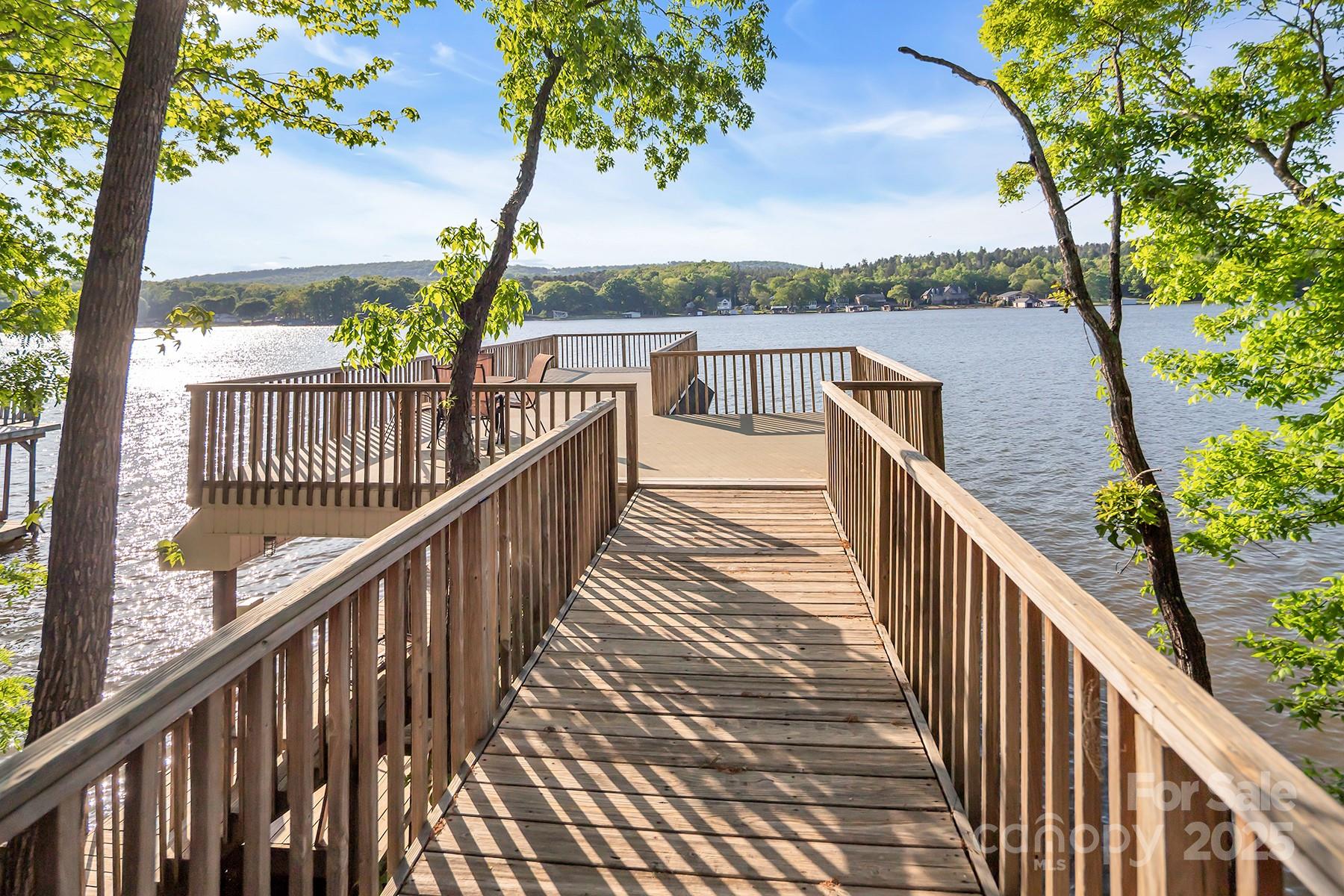 Seize a remarkable investment opportunity w/ this stunning Lake Tillery waterfront home perfect for vacation rentals! This custom built home boasts breathtaking views of the lake & offers a lifestyle that blends luxury & comfort. The home features 4 bedrooms plus a bonus room, 4 full baths, & one 1/2 bath. The interior has exquisite details like wormy maple & oak floors, cedar lined closets, tongue & groove cherry and wormy maple paneling accent walls. Main floor kitchen is equipped w/ solid oak cabinetry, granite countertops, center island & breakfast bar. Cozy up to 2 fireplaces, one adorned w/ dry stack rock, adding warmth to the home. Outdoors you’ll find 3 expansive entertaining areas: an open deck w/ Brazilian hardwoods overlooking the water, a screened porch, and a large covered patio perfect for peaceful relaxation. The property offers a deep water boat house w/ nearly 15 feet of depth, large sun deck, boat slip, & Jet Ski lift. Vacation renters will love this special property!