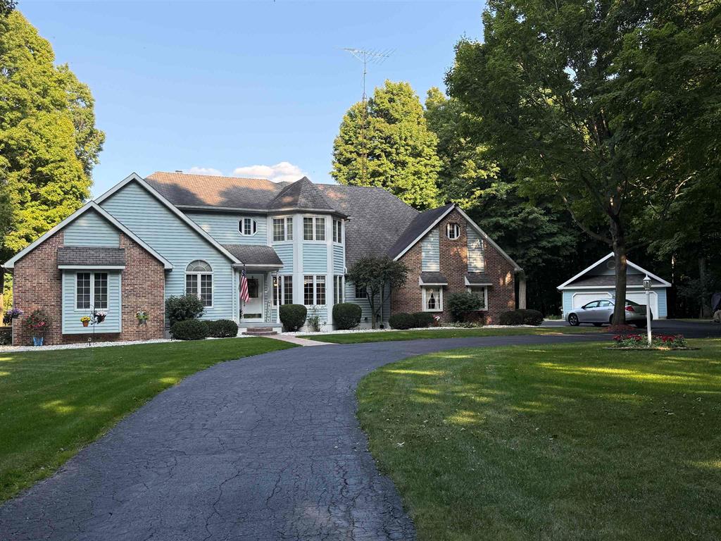 Escape to this stunning 15-acre wooded retreat, just 4 minutes from Interstate 69. This immaculate 4,600-square-foot home features breathtaking views from every room. Updated airy kitchen. First master suite, laundry and a spacious deck perfect for entertaining. Enjoy the convenience of a four-car garage (two attached, two detached), heated,water,air-conditioned 2-car garage with a loft. The pond is stocked with bass and hybrid bluegill. The lower level offers a second living area with a walkout. Surrounded by mature woods and abundant wildlife. This property is a true haven!