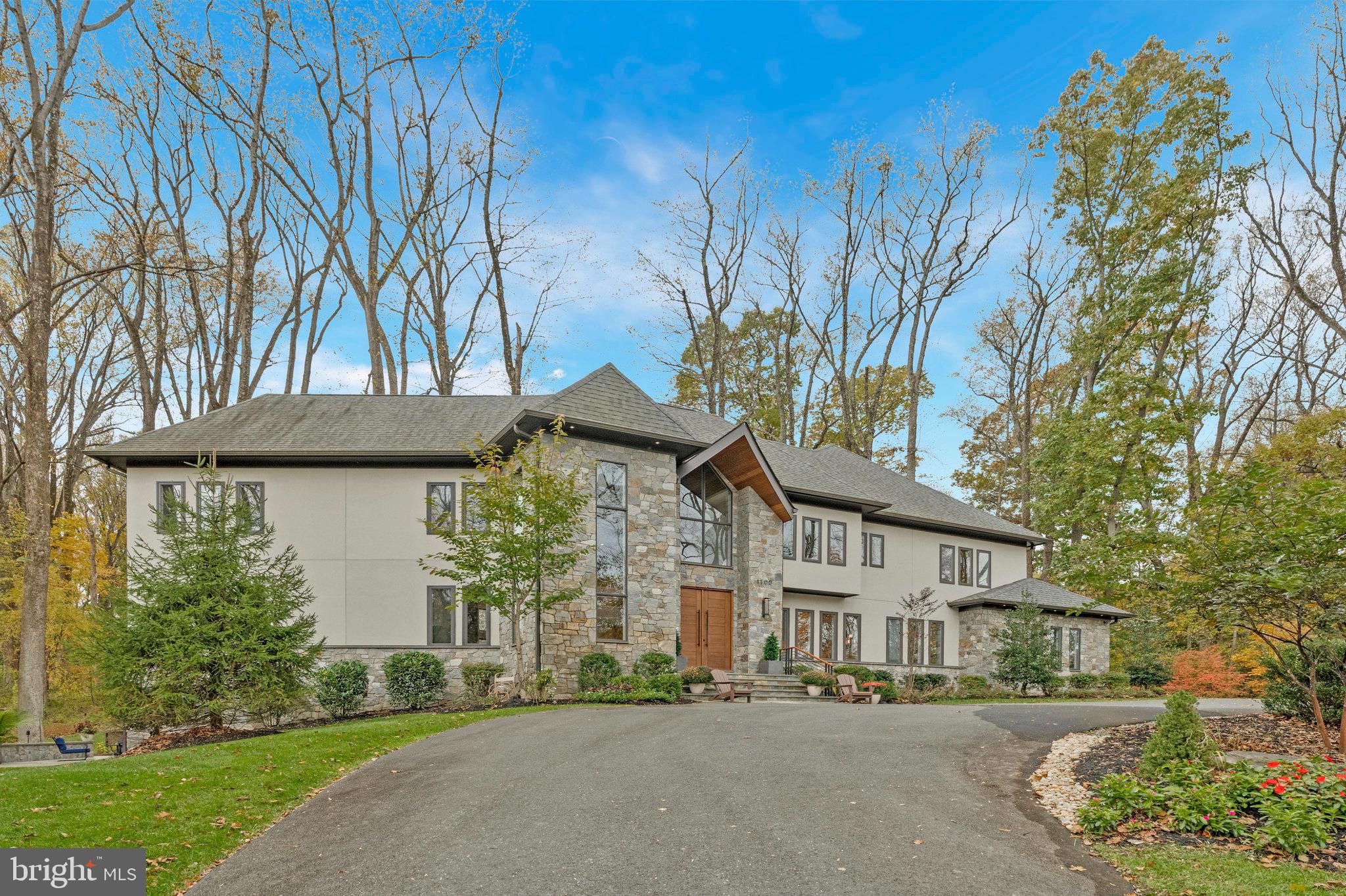 Every once in a while, you come across a life-changing homePoised above a serene pond and overlooking Meadowlark Botanical Gardens, this custom-built showpiece blends dramatic architecture with grounded luxury. Built in 2020, by EV Custom Homes, this one-of-a-kind masterpiece has been thoughtfully enhanced with nearly $185K in upgrades. Spanning 8,000+ square feet of finished living space on 1.81  private acres, this home is both an oasis and a launchpad for living well.Curb appeal begins at the tree-lined driveway, adorned with perfect landscape lighting, leading to this home’s beautiful crescendo of modernist style presented in stucco, stone, and cedar. An extraordinary 9-foot solid mahogany door opens to a soaring foyer trimmed in cedar and illuminated by a Sonneman pendant chandelier. From there, the light filled two-story great room impresses with mahogany-accented ceilings with 20+ led lights, a 16-foot slab fireplace, and a curved wall of custom windows framing the view of a sea of 100 ft trees like art.The gourmet kitchen includes exposed cedar beams and features ample soft close custom cabinetry and a Dekton slab waterfall counter on a massive island, Sub-Zero and Wolf appliances, including a built-in espresso machine, and a full wine bar. The layout flows from kitchen to dining area to the expansive curved Trex deck, creating effortless indoor-outdoor living.The main level also includes a richly trimmed home office with balcony access generating awe inspiring views that are guaranteed to spark jealousy on your next Zoom call. A formal dining room with designer wallpaper, multiple sitting areas, a butler’s pantry, and a mudroom with built-ins, and two half baths promise to make family living and entertaining a breeze. Upstairs, four spacious bedrooms each have a private en-suite bath with distinctive tilework. The primary suite is a true retreat, complete with tray ceiling, a sitting room with fireplace, a private balcony, wet bar & coffee station, and a spacious walk-in closet enhanced with custom shelving and lighting. The spa-like bath is finished in limestone, including 7 shower heads and a soaking tub.The lower level is your private clubhouse. Designed with a chic industrial vibe, it includes a rec room, a fireplace, a full wet bar, wine room, bedroom, and full bath. A mirrored-wall gym with retractable panels and specialty flooring offer effortless and private access to healthy living. Every inch of the property has been enhanced to support both ease and enjoyment. Automated blinds were added to the primary bedroom, baths, and office. There is a whole-yard invisible dog fence and an EV charger in the three car garage. Landscaping upgrades include a custom bridge expanding the rear yard, an automated irrigation system, a large stone patio with curved stairs, and a sculptural louvered enclosure for under-deck storage. The stone patio extends to a premium hot tub surrounded by woods and perfect for relaxing under the stars. It is your front-row seat to golden hour and quiet evenings ahead.Though you feel worlds away at this wonderful peaceful retreat, you are actually just minutes from Tysons, Reston, Wolf Trap, and the Metro. The charm of downtown Vienna, with its restaurants, local shops, and community events is nearby. You also enjoy close by walks on parkland trails and quick access cycling on the 45-mile W&OD National Recreation Trail. With nearly two acres of usable land, this property offers exciting potential for a future pool and expanded outdoor living.This is more than a residence. It’s a stunning handcrafted, light-filled experience curated for modern life, where healthy living, privacy, luxury, and natural beauty all come together for those that refuse to settle for ordinary.