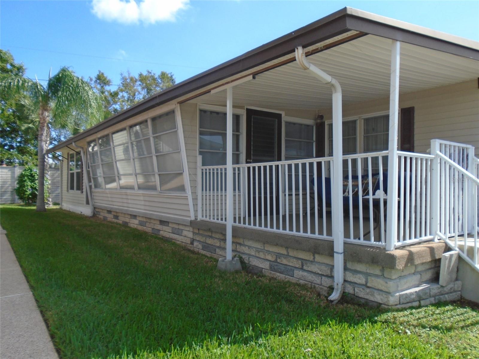 COMFORTABLE * AFFORDABLE * CONVENIENT...Sunset Palms! Lowest Price Two Bedroom in Sunset Palms * From the Welcoming Covered Front Sitting Porch to the Back Patio (with No Rear Neighbors!), this Home is Set Up to Enjoy the Florida Lifestyle. The Light Filled Living Room Hubs Off to the Right to a Second Front Living / Dining Area, or Straight Ahead to the Spacious Kitchen with Side by Side Fridge, Custom Coffee Bar Cabinet and Nearly New Stone Look Linoleum * From the Kitchen, Step Down to the Spacious Bonus Room (Heat & Air Here Too!). The Bonus Room has Sliders that Open to the Front Covered Carport. In the Back is a Separate Utility / Laundry Area that has a Door to the Back Patio. The Washer & Dryer are Nearly New...Lots  of Bonus Storage Here. The Hall Bath has a Tub / Shower Combination and Two Storage Closets. The Main Bedroom Features a Half Bath. In the Second Bedroom is a Seven Foot Double Wall of Closets. Heat and Air was New in 2022. There is a Back Exit / Entrance Gate Accessible Only to Residents by Key Fob. This Way Out provides Easy Access to the Nearby Walmart with a Golf Cart Path from the Park to the Store. Sunset Palms is Over 55, No Pet Park * Seasonal Rentals Are Allowed / No Annual Rentals * Share Valued at $55,000 is included in the Purchase Price.