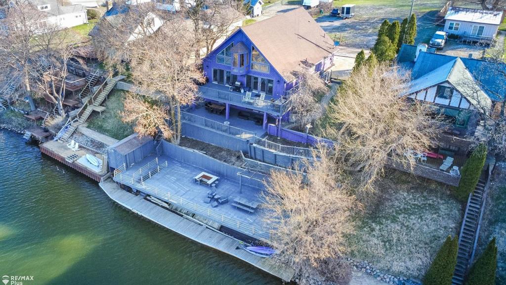 Wake up to breathtaking views of Lake Nepessing-an all-sports lake where every day feels like a vacation. With summer just around the corner, now is the perfect time to secure your slice of lakefront paradise. Whether you love boating, swimming, fishing, or simply embracing the lake lifestyle year-round, this property delivers it all. Nestled in desirable Elba Township, this stunning home offers 63+ feet of private lake frontage and convenient access to Interstate 69, along with nearby restaurants, shopping, and golf courses-combining peaceful waterfront living with everyday convenience.  Originally built in 1990 and recently renovated with a modern twist, this exceptional home features fully equipped upper and lower living quarters-ideal for multi-generational living, extended stays, or hosting guests in comfort and style. Designed for both relaxation and entertaining, the expansive two-story deck showcases spectacular sunset views over the water. Inside, the light-filled great room impresses with soaring ceilings and an open, airy design that maximizes natural light and lake views. The versatile loft offers endless possibilities-perfect as a primary suite, home office, or playroom-and includes access to a wraparound interior balcony overlooking the main living space. Spacious bedrooms provide comfort and privacy, with three featuring their own private full baths. This one-of-a-kind lakefront retreat truly must be seen to be fully appreciated.