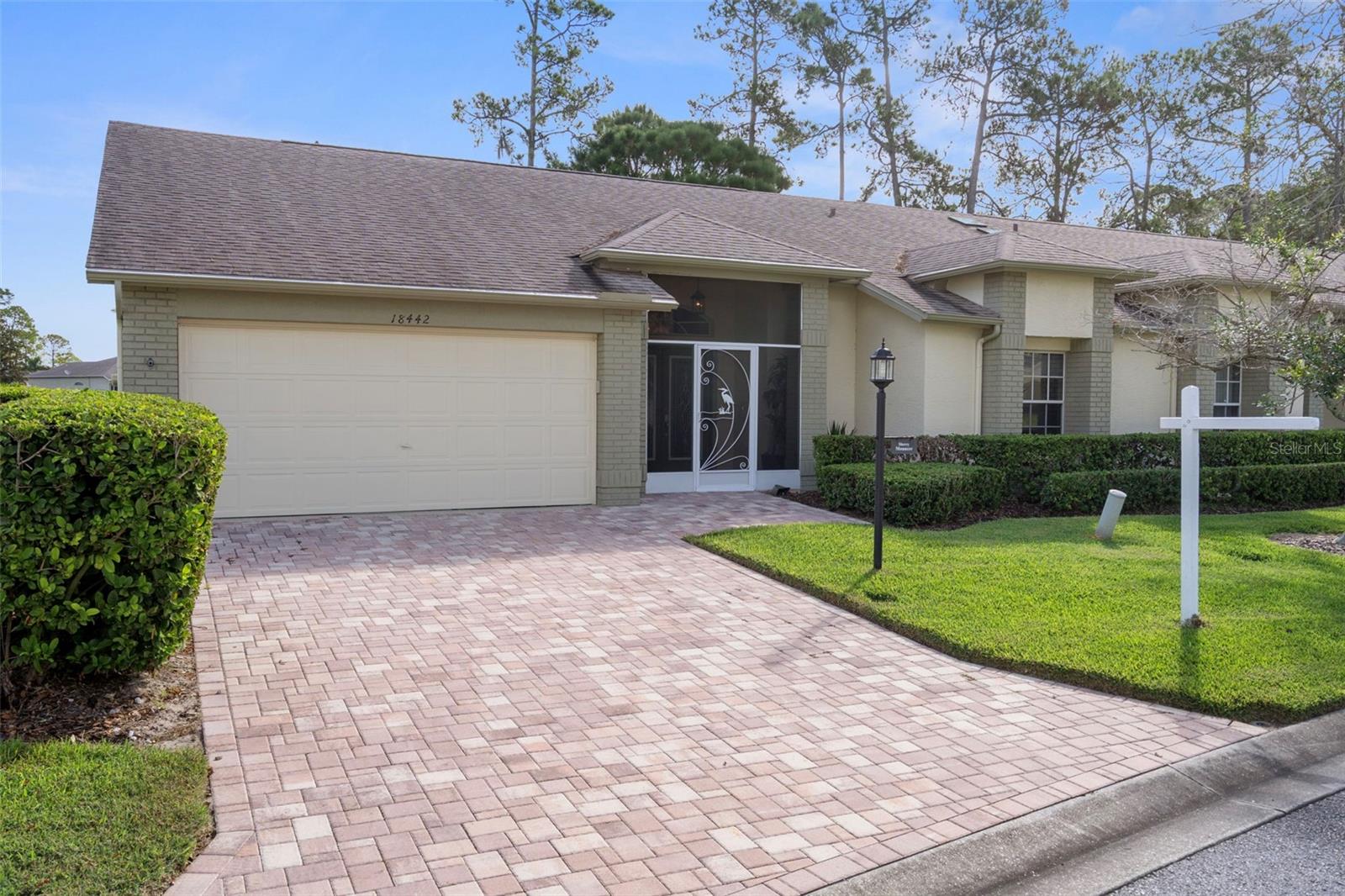 Model Perfect FULLY FURNISHED Luxury Villa with Golf Course Views! Discover elegance and ease in this impeccably updated end-unit Oakmont villa—an exceptional residence where every detail reflects quality craftsmanship and timeless design. No expense was spared in the transformation of this home, creating a stunning showcase ready to impress the most sophisticated buyer.  A welcoming covered front porch sets the tone for relaxed Florida living, offering the perfect spot to savor your morning coffee or unwind in the afternoon breeze. Step through the elegant double doors into a grand living area, where soaring cathedral ceilings and luxury vinyl plank flooring and a beautiful fireplace create a sense of sophistication.  The designer kitchen is a true centerpiece, boasting 10-foot custom cabinetry with soft-close features, quartz countertops, a stylish tile backsplash, GE Café appliances, and thoughtful storage including pull-out pantry shelves and a concealed trash cabinet. Bar-height seating invites casual conversation, while the breakfast nook, with a bay window and honeycomb blinds offers views of the golf course provides a serene dining setting. The well-planned layout ensures privacy and comfort. The spacious primary suite offers two walk-in closets and a luxurious en suite bath, while the guest suite—with a large walk-in closet and Murphy bed chest—doubles beautifully as a home office. Function meets refinement in the laundry room and butler’s pantry, which provide direct access to the garage and feature an additional sink plus newer LG washer and dryer. The garage itself includes a sealed epoxy floor, ample built-in storage, and a second refrigerator. Entertain or simply unwind in the expansive Florida room overlooking the 4th hole of the championship golf course—a perfect setting for both quiet mornings and evening gatherings.  The ample patio outside features an automatic retractable awning, giving you a convenient escape from the sun and weather, while still enjoying the outdoor lifestyle and your view of the golf course.  Recent upgrades add confidence and value, including:  New roof (2020)  New A/C system (2022)  New water heater and softener  Extensive designer updates throughout  Offered fully furnished with high-quality, designer pieces and accessories, this home is truly turnkey luxury. Just bring your suitcase and begin living your best Florida life.  About Heritage Pines:This premier 55+ community offers a resort-style lifestyle with a championship golf course, elegant clubhouse, heated pool and spa, tennis and pickleball courts, fitness center, on-site dining, and a vibrant calendar of social events and clubs.  The low HOA fee includes cable, internet, lawn care, exterior painting, irrigation, and pest control—ensuring effortless living in a beautifully maintained community.  Welcome to a home where luxury, leisure, and lifestyle meet seamlessly.