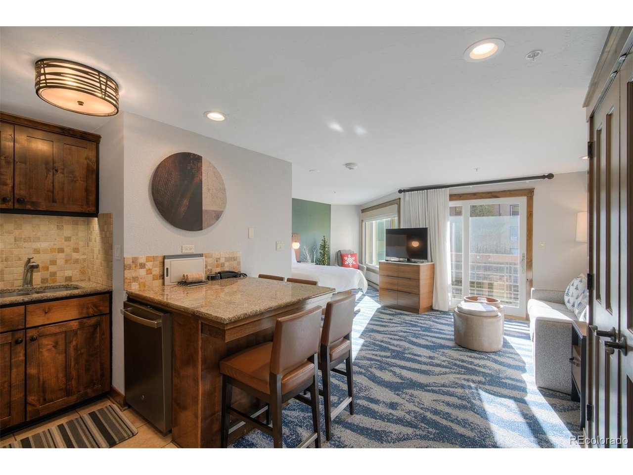 Welcome to a rare opportunity to own a wholly owned, ski-in/ski-out residence in the heart of Breckenridge at the sought-after Marriott Vacation Club. Overlooking the river, Maggie Pond, and the ski slopes, this beautifully updated deluxe studio offers an exceptional blend of location, lifestyle, and income potential. The bright, thoughtfully designed L-shaped studio features an oversized window with direct slope views, filling the space with natural light and mountain scenery. The efficient layout separates the kitchen and sleeping area and comfortably accommodates up to four guests with a premium Marriott queen sleeper sofa. Built to last, the unit features thick walls and no popcorn ceilings, highlighting quality construction rarely found in mountain properties.  Offered fully furnished and accessorized, this turn-key condo boasts a strong rental history, including $58,683 in self-managed rental net income in 2025, with rents sufficient to cover HOA dues.  Owners may choose hands-on management or enjoy effortless professional rental management through Marriott. This condo is located in Breckenridge's Resort Zone, allowing for short-term rentals with no waiting list or licensing delay. Resort-style amenities include a full-size outdoor heated pool, four hot tubs, fitness center, 24/7 front desk and check-in, free unassigned owner parking, and laundry facilities conveniently located on the unit's floor. Weekly activities for kids and adults enhance the resort experience. Situated in a quiet corner of the property next to Maggie Pond, the condo offers peaceful surroundings while remaining just steps from the slopes. A short walk via the garage pool exit leads directly to Main Street Breckenridge and the Village, placing dining, shopping, and entertainment within easy reach. Owners may also deposit weeks into Interval International for travel exchanges worldwide. A rare chance to own a true Breckenridge ski property with premier resort living!