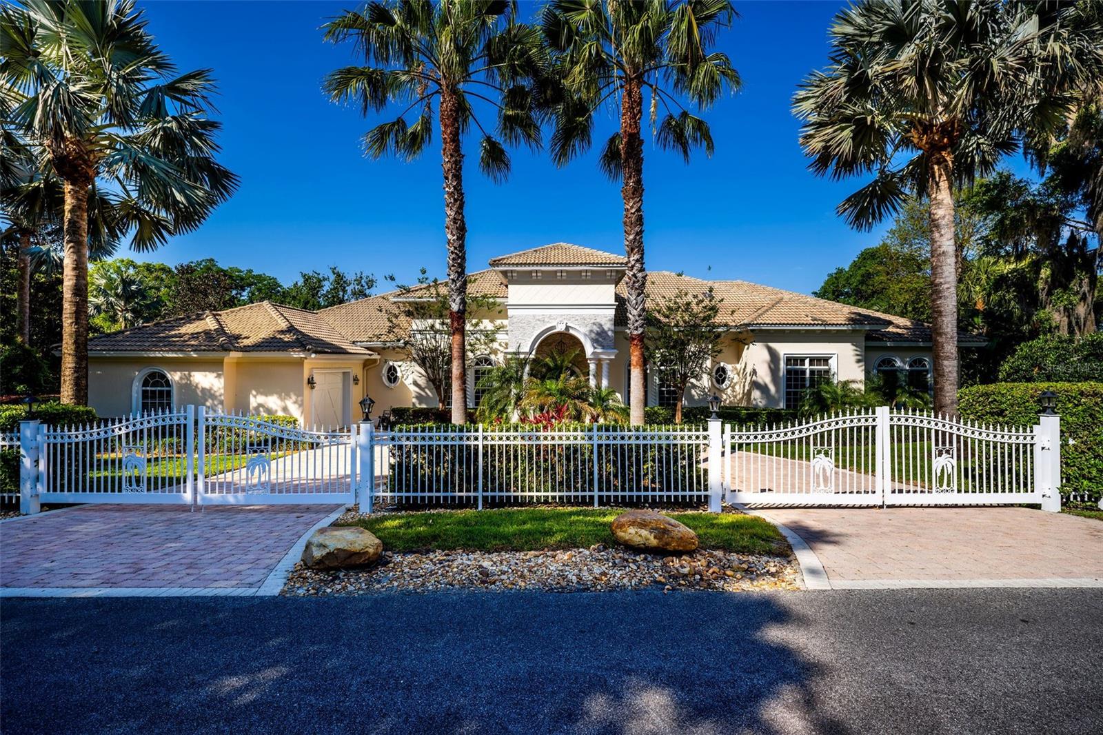 Discover an extraordinary LAKEFRONT retreat in the heart of Lake Mary! This stunning 4-bedroom, 4-bath custom home boasts an INFINITY POOL and sits on a PRIVATE peninsula with sweeping, panoramic views of Big Lake Mary—a true rarity. Embrace the lifestyle you’ve always dreamed of in this 5,000 sq.ft. paradise, crafted with exceptional quality and built to exceed Orlando-area structural and hurricane standards. 
Step through custom double iron doors into a world of architectural elegance: soaring arches, coffered ceilings, crown molding, and expansive windows frame breathtaking water and pool vistas. The open-concept design flows seamlessly, featuring a sophisticated office with high-end built-in cabinetry, a spacious formal dining room, and a living room with a cozy fireplace. The heart of the home is a newly remodeled gourmet kitchen with a massive waterfall island and dinette area, overlooking the expansive 26x23 family room featuring panoramic outdoor water views —and perfect for game nights or movie marathons.
The thoughtful 3-way split bedroom layout includes a luxurious owner’s suite with spacious en-suite bath and generous closet, plus two additional bedrooms with private baths. But the real showstopper is the outdoor lakefront OASIS: a covered porch with a TV, fireplace, built-in grill, stone accents, and a 40’ lighted, retractable awning. Dive into the stunning infinity pool with three waterfall fountains, unwind on the expansive paver patios and deck, or practice your swing on your private putting green.  The ultimate setting for savoring quiet relaxation or throwing unforgettable get-togethers.
With 350’ of water frontage on over 2 acres of lush, landscaped grounds, this estate offers a private dock with a covered boat lift, double floating jet ski lifts, and one of the lake’s few in-water boat ramps. Additional highlights include a circular driveway, extensive paver drive, a 3-car side-entry garage with Race Deck flooring, a concrete tile roof, poured concrete walls, and hurricane-impact doors and windows—all on a private, gated lot with no HOA.
Big Lake Mary, a resident-only private lake, invites you to boat, ski, fish, or savor stunning sunsets. Nestled in a prime location with Lake Mary’s top-rated schools, this home is just minutes from shopping, dining, downtown Lake Mary, SunRail, I-4, 417, and Sanford International Airport. Don’t miss this one-of-a-kind gem—opportunities like this don’t come along often! Note: This home may be under audio/visual surveillance.
