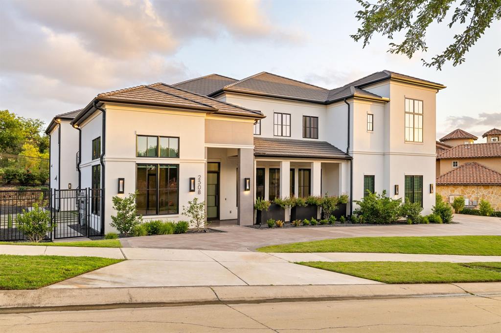 Welcome to one of the most extraordinary contemporary estates in North Texas, privately tucked behind the exclusive manned gates of Enchanted Hills within the prestigious Castle Hills community. Designed to impress at every turn, this architectural masterpiece masterfully blends bold modern design with timeless luxury, creating a home that is as breathtaking as it is livable. Step through the grand entry and you're immediately greeted by soaring ceilings, walls of dramatic glass, gleaming floors, and a spectacular floating staircase that serves as a true work of art. A private elevator provides effortless access between both levels, offering the perfect balance of luxury and convenience. Every detail of this residence has been thoughtfully curated for those who love to entertain without compromising everyday comfort. Expansive living spaces flow seamlessly from one room to the next, creating an atmosphere that is equally suited for intimate evenings or unforgettable celebrations. At the heart of the home is a stunning designer kitchen that is as functional as it is beautiful. Anchored by an oversized island, the space features custom cabinetry, premium appliances, and sophisticated finishes. Just beyond, a fully equipped secondary chef's kitchen allows for effortless entertaining, keeping the main kitchen immaculate while hosting gatherings or catered events.A distinguished private office showcases floor-to-ceiling custom built-ins, delivering an inspiring workspace with both elegance and functionality.One of the home's most captivating features is its seamless connection to water and nature. Custom indoor and outdoor waterfalls create a peaceful ambiance rarely found in residential design. This is far more than a luxury home—it's a statement of design, craftsmanship, and lifestyle. Created to evoke emotion, inspire connection, and deliver an unparalleled living experience in a coveted gated communities.