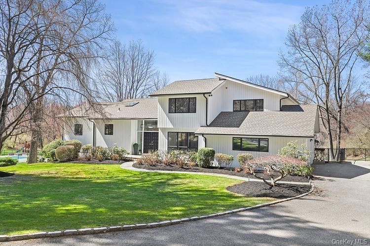 Experience luxury living in this newly fully renovated, turn-key home set on the prestigious Round Hill Rd in Armonk, with the added bonus of the opportunity of joining the Windmill Club. Boasting an expansive open floor plan, large rooms, vaulted ceilings, wide planked white oak hardwood floors, this designer inspired home is filled w/ high end finishes throughout. The large open living room & family room, with vaulted ceilings and free standing, two-sided gas fireplace leads into the most elegant chef's kitchen, fully equipped with stainless steel Thermador appliances (including Thermador Professional Range), quartz countertops, 8 ft. center island and more. The mudroom, with its outfitted cubbies, is situated conveniently to the large 2-car garage and driveway. The formal dining room, with its elegant chandelier and transitional partition; and stunning powder room with a floating vanity and white oak acoustic modern paneling add beauty and uniqueness of the first floor. The primary bedroom ensuite will dazzle you with a vaulted ceiling, spacious, elegantly customized walk-in closets (withe self-closing barn doors), private deck off the bedroom, and a glorious well appointed bathroom with heated floor, stunning cabinetry, deep oversize free standing tub, oversized shower, with digital smart water faucets and shower displays, smart heated toilet, and heated towel bar. Three additional generous sized bedrooms, with custom outfitted closets, and exquisitely designed full bathroom with waterfall faucet, LED mirror and glass enclosed shower, complete the second floor. The basement includes large recreation spaces, a full laundry room with new washer/dryer, farm sink, butcher block countertop, cabinetry and work space, full bathroom, office/den, utility room with 2 new furnaces, new water heater, new vents, new smart thermostats, generator, and lots of storage. The newly renovated maintenance-free deck, spanning across the back of the home, is a perfect spot for entertaining, and enjoying an expansive park -like backyard, including a private in-ground heated pool with pool shed (New pump and filter installed in pool July 2025). In addition to the amazing features of this home, you have the opportunity to join the Windmill Club, as home comes with the MEC, offering many amenities, including a beach, lake for swimming, clubhouse and tennis.