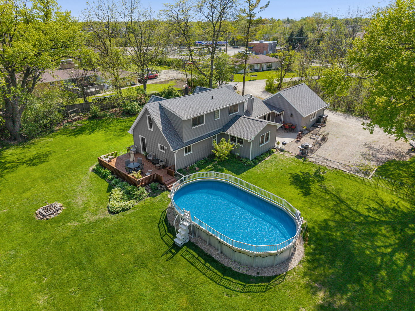 Cool Off This Summer in Your Own Backyard Oasis! While the temperatures are rising, you'll be enjoying your own private pool in this beautiful country retreat. Set on a picturesque one-acre lot just minutes from town, this is anything but a cookie-cutter home. Designed for comfortable everyday living and effortless entertaining, the sun-filled interior features a stunning updated kitchen with NEW appliances (2019) and luxurious heated floors. The open-concept layout flows seamlessly from the inviting family room with a cozy wood-burning fireplace to the expansive great room with access to the oversized deck. A screened porch provides the perfect place to relax and take in the peaceful country setting. Outdoor living is exceptional with multiple spaces to enjoy, including a patio just off the eating area and a NEW above-ground pool (2024) perfect for summer fun with family and friends.  The convenient main-floor primary suite offers privacy and comfort, while upstairs you'll find two charming dormer bedrooms with custom millwork and a whirlpool tub for a relaxing spa-like retreat. Hardwood floors throughout much of the home add warmth and timeless character.  This home has been extensively updated, giving buyers confidence for years to come. Recent improvements include a NEW roof, siding, gutters, and select windows (2024), NEW boiler and tankless water heater (2026), and a BRAND-NEW 1,500-gallon septic system (2026), a significant investment that provides outstanding value and peace of mind. Additional Anderson windows are approximately 10 years old. The attached two-car garage includes an oversized walk-up loft, offering exceptional storage or the opportunity for a future workshop, studio, or hobby space. Offering approximately 2,300 square feet on a full acre, this move-in-ready home combines modern updates, outdoor amenities, and the privacy buyers crave, all just minutes from shopping, dining, and everyday conveniences. Homes with this combination of land, updates, and lifestyle are hard to find. Don't miss your opportunity to make it yours!