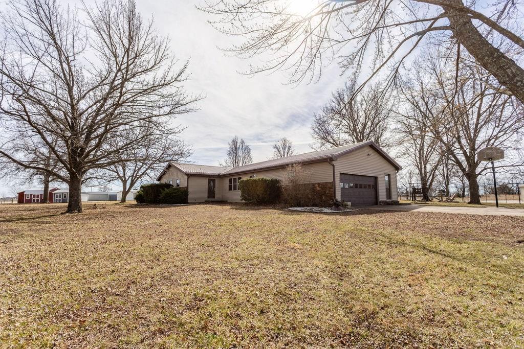 This cozy 3 bed, 2.5 bath 1,800 square foot home sits on a spacious 8 +/-acres just off the highway. With big mature shade trees in the front yard and acres of open pasture in the back, it is a perfect fit for anyone looking for a homestead. The back pasture has a nice-sized pond perfect for watering livestock and fishing just out your back door. A 34’x36’ barn provides adequate room for protecting livestock and equipment from the elements. The 18’x20’ carport is perfect for storing small equipment, and the small storage shed is great for garden tools, feed, and supplies.The home is spacious with a large living and dining area, great for entertaining guests and big families. The master bedroom has a full bath attached, which provides privacy and convenience. The two bedrooms are served by a full bath in the hallway, and a half bath located near the back door is great for guests. The large kitchen is equipped with Amish-built oak cabinets that are a prize for any home chef. Right outside the kitchen is a screened-in 12’x18’ porch with a large deck, making a great space to entertain guests outside while the grill master is hard at work. Kids can enjoy a spacious backyard, an insulated playhouse, and the large dog kennel helps keep food on plates and away from furry burger monsters looking for snacks.When cold days hit, you won’t need to refill propane tanks since natural gas provides fuel for heat in the house and the attached garage. A short drive down the highway is a Wal-Mart, Tractor Supply, lumber yard, and excellent BBQ.