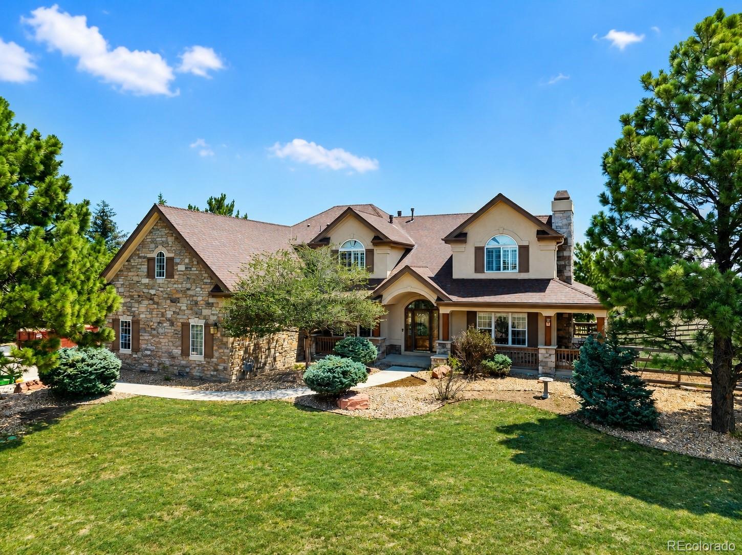 Welcome to the lifestyle you've been looking for in the highly sought-after Sky Rim community. Situated on just over 5 acres, this exceptional 6-bed, 5-bath home offers privacy and flexibility just minutes from Mainstreet Parker, Southlands, E-470, C-470, and an easy commute to the Denver metro. Step inside to a welcoming foyer that creates a warm first impression. Soaring ceilings, oversized windows, and a thoughtfully designed layout fill the home with natural light. The living room is anchored by a striking granite-surround fireplace and flows seamlessly into the kitchen, creating one cohesive gathering space with direct access to the deck from both rooms. The chef's kitchen features granite countertops, double ovens, abundant cabinetry, a spacious center island, dedicated coffee bar, and sunny breakfast nook. A main-level bedroom and nearby 3/4 bathroom provides the perfect guest suite or quiet home office.Upstairs, the spacious primary suite features a fireplace, private balcony, oversized walk-in closet, and luxurious five-piece ensuite bath. Three additional bedrooms complete the upper level, including one with a private ensuite and two connected by a Jack-and-Jill bath. The finished basement adds versatile living space with a fully equipped theater room, large family room with a wet bar, and an additional bedroom with its own bathroom and walk-in closet.Outside, the property offers open space for horses, outdoor recreation, or simply enjoying the peace and privacy of acreage living. The community well provides a reliable water source without the maintenance of a private well. An oversized attached three-car garage and additional detached three-car garage provide exceptional space for vehicles, recreational toys, equipment, storage, hobbies, or a workshop. This is a rare opportunity to enjoy acreage living with room to spread out while remaining close to shopping, dining, recreation, and everything Parker has to offer. Schedule your private showing today!