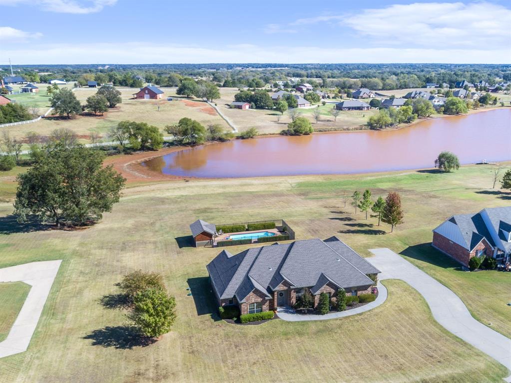 SHOWINGS BEGIN on SATURDAY, OCTOBER 25. OPEN HOUSE SUNDAY, OCTOBER 26 FROM 1-2PM ONLY.   LAKEFRONT 1.36 ACRE LOT IN GATED COMMUNITY---BEAUTIFUL POOL & POOL CABANA--NEW PAINT & CARPET JUST COMPLETED--NEW ROOF SHINGLES IN 2024--UPDATED APPLIANCES--SPLIT BEDROOM PLAN--LARGE, UNDERGROUND STORM SHELTER and much more!   LESS THAN 5 MILES TO THE OU CAMPUS, check out this 4 bedroom prize with 3 FULL BATHS and UPDATES GALORE.  Beautiful, engineered wood flooring graces the entry, living and formal dining areas.   LIGHT AND BRIGHT WITH WINDOWS OVERLOOKING THE LAKE from the living room & primary bedroom.   RECENT UPDATES also include:  4-ton American Standard HVAC system installed in April 2022, hot water heater in August 2021, well pressure tank in Dec 2023, dishwasher, microwave and pool pump this year; Class 4 (impact resistant) roof shingles, synthetic felt and 3" (oversized) guttering & downspouts in March 2024.   Save money on your insurance cost with Class 4 shingles!   Ask your insurance agent about this, and be sure to ask for FULL REPLACMENT COVERAGE when you get an insurance quote.   11,000 GALLON SPORT POOL ranges from appx 4' to 6' in depth, has fiber-optic lighting and a HEDGE OF 3-4' HIGH SHRUBS & WROUGHT IRON FENCING that privatizes your pool while you swim.   The GATED WELLINGTON LAKES OFFERS A FISHING DOCK, OUTDOOR BASKETBALL COURT AND LAKE ACCESS AROUND THE PERIMETER OF THE LAKE for access by all residents.    Students already attending Norman Schools have typically been allowed to remain in the Norman School district.  Check with Norman Schools administration for more information.  Virtual staging has been used in some pictures to show approximate room sizes and decorating ideas.