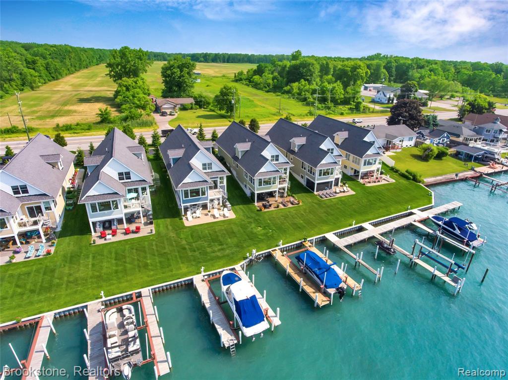 Luxury lakefront living with unmatched access and views. Rare opportunity to own a custom 3-level home offering over 3,500 sq ft of finished space and direct access to the water.Experience stunning sunrises and breathtaking sunsets from your home, yard and private docks, fully equipped with a 24,000 lb electric boat hoist, additional slip options, dockside electric and water, and remote wave runner/jet ski lift-an exceptional setup for boating and fishing enthusiasts.The main level features a bright, open layout with a spacious living room, fireplace, sunroom, kitchen, bedroom, full bath, and convenient laundry. Upstairs offers three additional bedrooms and two full baths, while the walkout lower level is built for entertaining with a bar, expansive living/dining areas, full bath, fireplace, and abundant storage.Step outside to a beautifully finished, partially covered aggregate patio complete with hot tub, outdoor TV, and remote screens for added comfort and privacy.Enjoy year-round waterfront living—boating, fishing, kayaking, and winter activities-all from your own backyard. Ideally Located just minutes from downtown New Baltimore’s restaurants, public marina, and shops, with quick access to I-94.A rare opportunity to experience refined lakefront living with exceptional functionality.