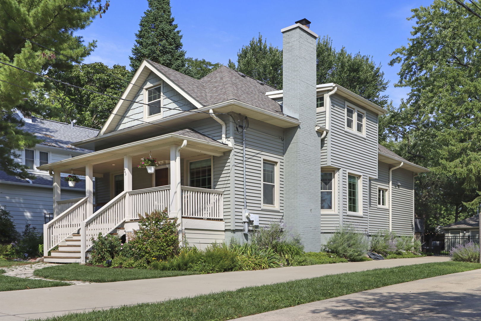Outstanding opportunity in the heart of Deerfield to own a beautifully updated 4-bedroom, 2.1-bath home that blends early 20th-century character with extensive modern improvements. Built in 1914 and thoughtfully renovated over the years, this inviting home offers a versatile floor plan and a prime location close to downtown Deerfield, the Metra station, parks, library, shopping, and restaurants.  A rebuilt front porch provides a welcoming first impression and a comfortable place to relax outdoors. Inside, the spacious living and dining areas showcase original wood paneling, built-in storage, hardwood floors, and a wood-burning fireplace. An adjoining den with built-in shelving offers flexible space for a home office, reading room, or additional sitting area.  The custom kitchen, renovated in 2017, is designed for both everyday living and entertaining, with a large center island, high-end stainless steel appliances, quartzite countertops, extensive cabinetry, and views of the backyard. A nearby mudroom and updated powder room provide convenient access to the rear deck.  The first-floor primary suite, completed in 2017, features a walk-in closet, additional double closet, and private bath with a walk-in shower and heated floor. Upstairs, three additional bedrooms are complemented by a spacious family room that provides an ideal setting for relaxing, homework, games, or gatherings. The second-floor full bath was renovated in 2019 and includes a tub, while additional closet space provides valuable storage.  The finished lower level expands the living space with a recreation room and separate office or study, along with laundry, mechanical, and storage areas with exterior access.  The fully fenced backyard is designed for outdoor enjoyment with a patio, fire pit, string lighting, dog run, and established perennial landscaping. An oversized 2.5+ car garage and extra-long concrete driveway installed in 2020 provide exceptional parking and additional outdoor space.  A new roof was installed in 2024, and additional improvements include updated windows, gutters, siding, and numerous other enhancements. A rare combination of character, space, updates, and an outstanding central Deerfield location. A very special home, Don't Miss!