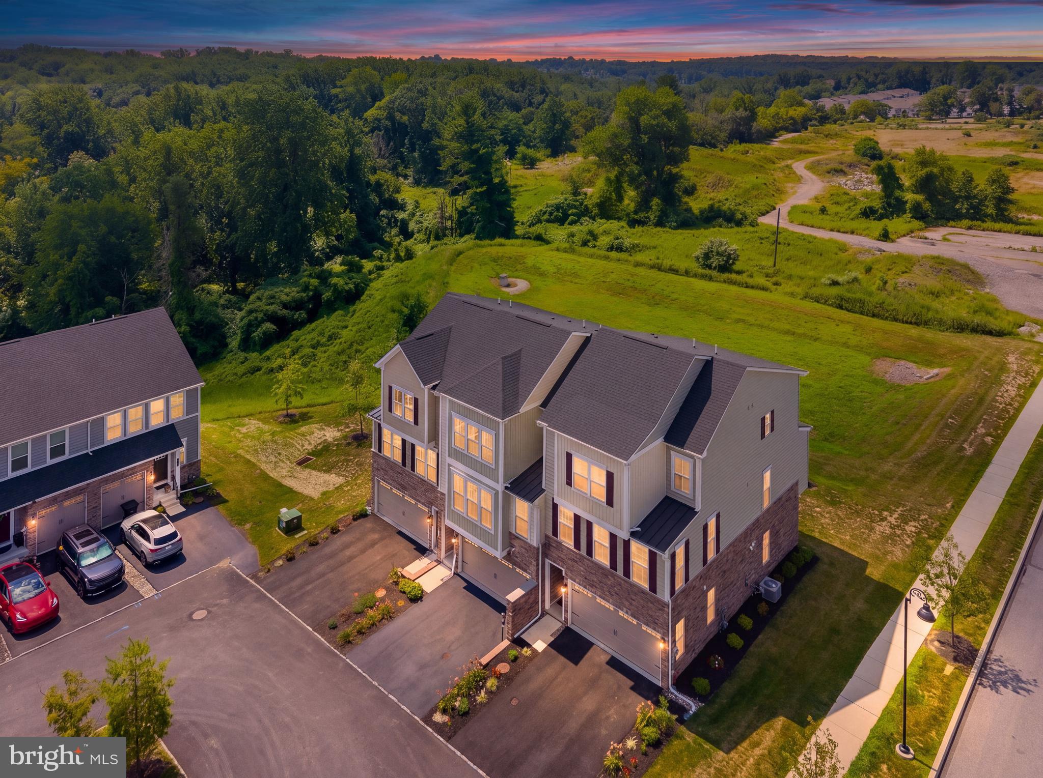 Welcome home to 127 Kyle Square, a meticulously maintained corner property in Media’s highly desirable Ponds Edge community! This stunning home features 3 bedrooms, 2 full bathrooms, and 2 half bathrooms, plus a versatile entry-level bonus room perfect for a playroom, home office, gym, or guest space.Step through the front door into a welcoming foyer complete with a built-in storage bench, coat closet, half bath, and interior garage access. Just beyond, the bright bonus room offers direct access to the rear yard.Head upstairs to the main living level, where you are instantly greeted by an abundance of natural light and upgraded hardwood floors. The chef-inspired kitchen is an absolute dream, featuring a massive 8-foot island with seating for up to six, crisp white shaker-style cabinetry, premium quartz countertops, and a farmhouse sink. The upgraded appliance package includes a 5-burner gas slide-in stove and a built-in wall oven with a convection microwave, all beautifully accented by a subway tile backsplash. Adjacent to the kitchen is a spacious dining area that comfortably seats 8 to 12 guests, as well as an expansive living room featuring a beautifully appointed half bath.For seamless indoor-outdoor living, sliding glass doors off the kitchen lead to an amazing covered balcony. Complete with an outdoor gas fireplace, ceiling fan, and exterior lighting, it is a true private oasis.On the upper level, you will find two generously sized bedrooms with custom built-in closets, served by a full hall bathroom with gorgeous tile work. Down the hall, the primary suite serves as a tranquil retreat, offering tray ceilings, sweeping views of lush greenery, and a walk-in closet with custom built-ins. The luxurious en-suite bathroom includes a dual vanity, upgraded black hardware, and a stunning Roman walk-in shower with dual shower heads.For added convenience the oversized two car garage was drywalled, insulated and has custom built in storage. Packed with premium builder upgrades and thoughtfully cared for by the current owners, 127 Kyle Square is a rare find. Don’t miss your opportunity to own this spectacular property in a prime Media location!