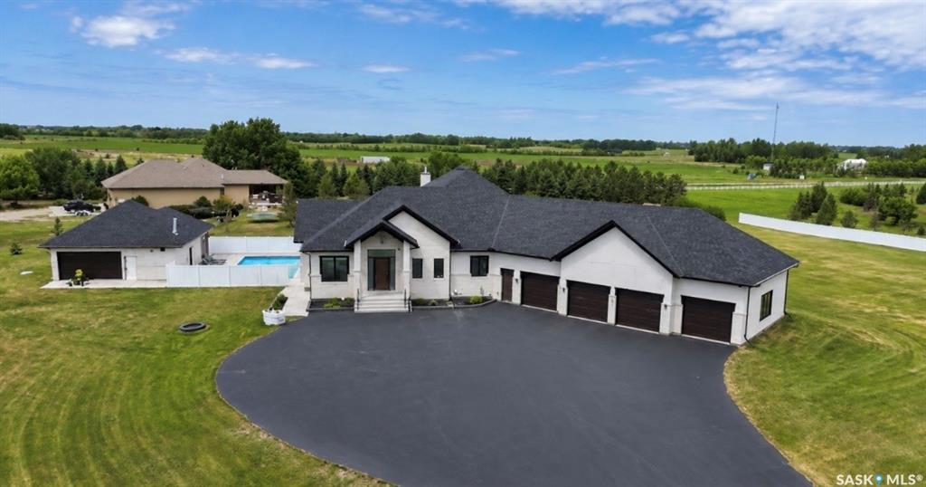 Luxury estate bungalow at Casa Rio East, situated on 2.79 acres, offering 4,171 sq’ plus a fully dev basement and resort-style grounds with a pool and outbuilding. Exceptional construction and mechanical systems throughout, including commercial-grade Ledcor construction. Designed for family living and entertaining. You’re welcomed by a large entry that opens to a grand living space with a central stone fireplace, walls of windows, a large dining area, and a chef-worthy kitchen. The kitchen boasts premium Miele appliances, an oversized island, a separate fully equipped butler’s kitchen, commercial-grade hood fan, and much more—exceptional detail was incorporated throughout. A 4season sunroom with stone fireplace connects to the dining area and overlooks the grounds. The main floor offers three generous bedroom suites, including an impressive primary retreat with a spa-inspired ensuite and dressing room. In addition, the main floor has a large office, laundry room, and boot room with access to the attached 4-car. The walkout lower level is a complete family entertainment retreat. This level includes a secondary kitchenette, dedicated theatre room w/ 120” screen & 4K projector, TV lounge, fitness room (could be a bedroom), massive playroom, and an additional luxury bedroom suite with a full bath, plus 2-piece bath. The backyard is resort-worthy, centred around a saltwater pool and hot tub area, with a separate detached double garage plus an adjoining pool house featuring a kitchenette and 3-piece bathroom. The grounds are fully irrigated with 160 sprinkler heads and drip irrigation to 80 trees, wireless controls with rain sensors, and extensive landscaping. See specification list: high-velocity furnaces, 10KW solar system, smart toilets throughout, Dura Built windows, 5-zone climate control, Control4 automation, 3 Valor fireplaces, in-floor heating in basement and garage, well for irrigation, detached heated double. Minutes south of Saskatoon.