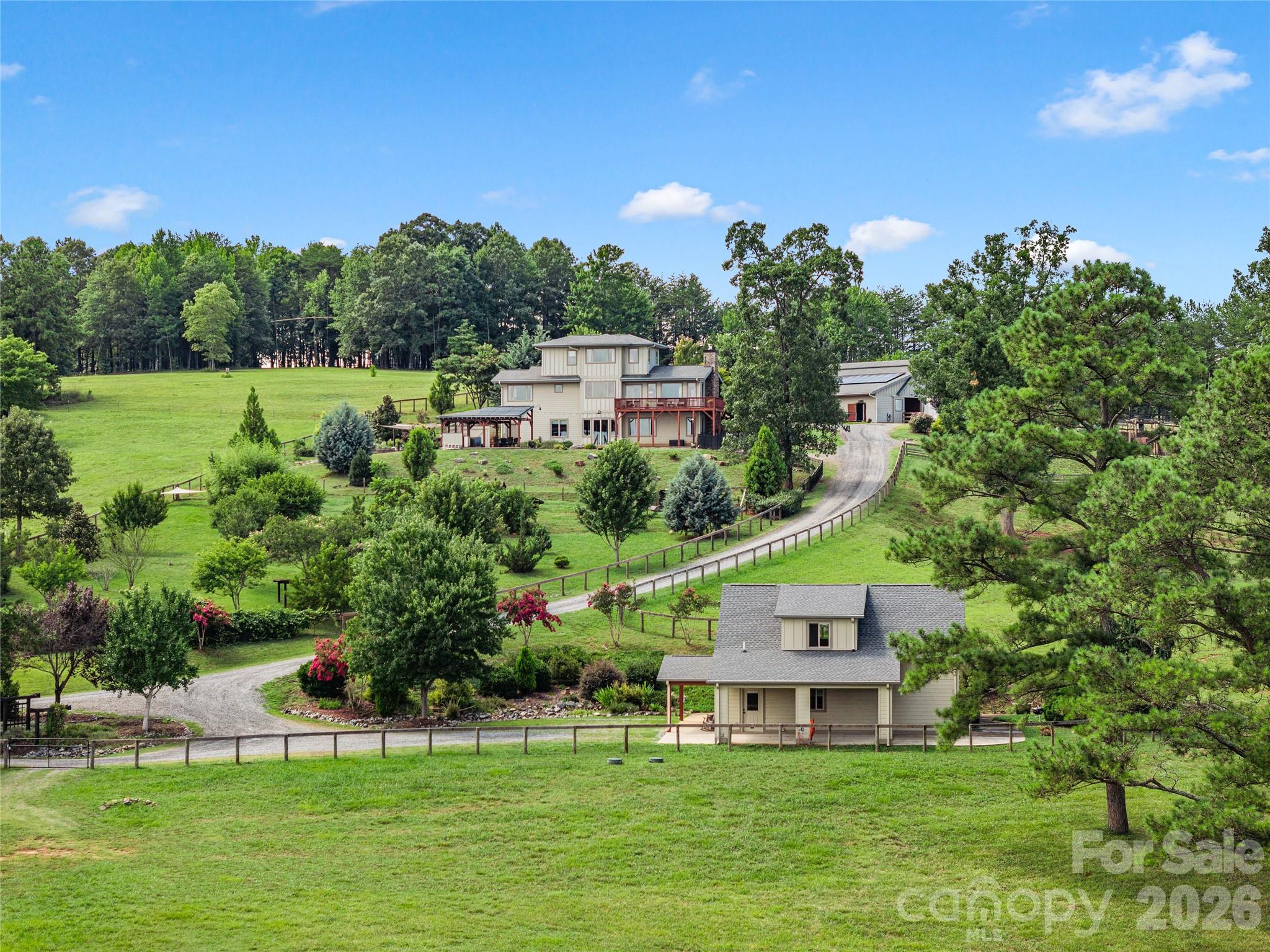 Some properties are built. Others are thoughtfully created.Set on 18.19 acres with direct access to FETA trails, this purposefully designed estate pairs a custom-built residence, beautifully appointed guest house, and exceptional equestrian facilities for those who want to embrace an extraordinary equestrian lifestyle while enjoying the rewards of thoughtfully cultivated country living, all set against long range views of rolling landscape.Every aspect of the property reflects careful planning. The custom-built residence features an 11 kW solar array, a 15 kW Franklin whole-home battery system, and a 7.5 kW backup generator, providing peace of mind in every season. A soaring stone fireplace and vaulted ceilings anchor the great room, where walls of windows frame the surrounding landscape. Walnut milled directly from the property crowns the fireplace mantle and appears throughout the home, a subtle reminder that the craftsmanship extends beyond the walls themselves. Upstairs, the primary suite overlooks the pastures and hills beyond, with a spa-inspired bath finished in natural stone and a walk-in shower designed for unwinding after a day outdoors. The unfinished basement is already equipped with radiant in-slab heat, framed for a future two-bedroom, 1.5-bath expansion with multiple flex spaces, and plans are available for the next owner. The recently completed guest house offers its own well and septic, creating exceptional flexibility for guests, multigenerational living, or a private home office.Designed with horse and rider in mind, the professionally equipped barn features four stalls, each with an attached walk-out paddock, direct track access to pasture, an 80' x 175' arena with GGT footing, a wash stall, tack room, workshop, and laundry, creating an efficient setup that's equally suited for everyday riding and serious training.Beyond the barn, the property embraces a lifestyle that's increasingly difficult to find. Rolling fenced pasture gives way to an established orchard, raised garden beds, herb gardens, and space for small livestock, creating an opportunity to cultivate the land as intentionally as you enjoy it.When the work is done, the setting shifts effortlessly to relaxation. A fiberglass pool with solar thermal preheat, an automatic cover, and a low-chlorine filtration system is complemented by a poolside pergola  and outdoor kitchen, creating an inviting space for entertaining family and friends.Just minutes from the heart of shopping in Landrum or Tryon, this is more than an equestrian property. It's an estate thoughtfully designed for generations of memories, where exceptional horse facilities, refined living, and a genuine connection to the land come together in one remarkable offering. For additional photos and floor plans visit the virtual tour.