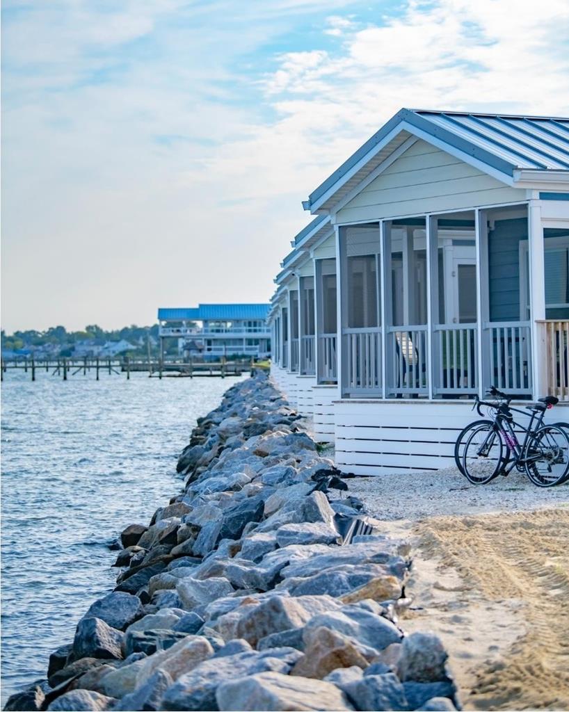 Welcome to BluFin,  a waterfront retreat nestled on Chincoteague Island. This serene escape is shaped by salt air, sunset skies and the rhythmic call of the tide. This property offers a rare blend of small town charm, waterfront proximity coupled with a strong investment potential. This coastal inspired unit offers bright open floor plan, 2 br and 1 bath, full size appliances, as well as incredible views and serene surroundings.   This is being offered with a land lease.