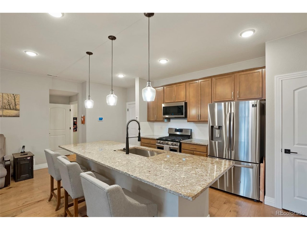 Public RemarksWelcome to your like new (2020) townhome in The Villages at Buffalo Run! This modern, two-story beauty offers 3 spacious bedrooms and 3 bathrooms across 1,654 square feet of well-designed living space. As you step inside, you'll be greeted by engineered hardwood floors on the main level, leading to a stunning kitchen that's perfect for hosting. Enjoy granite countertops, a large kitchen island, and sleek stainless steel appliances that make cooking a joy. The custom black metal railing adds a stylish touch as you make your way upstairs. Convenience is key with a custom chairlift installed in 2020 and 9-foot ceilings on the first level, creating an open and airy atmosphere. The upper level features 3 spacious bedrooms, 2 bathrooms, and a laundry room with ample storage washer and dryer are included. Extra perks include a tankless hot water heater, keypad entry, and a Honeywell thermostat for your comfort. The home also comes with a Simplisafe system for added security. The oversized two-car garage provides plenty of room for a workbench and tools, making it an ideal spot for any project. Situated on a 1,307 square foot lot, this townhome is close to various shopping and dining options. Plus, you'll have easy access to highways and be just 20 minutes from DIA. Don't miss out on this fantastic opportunity to own a contemporary and convenient home in Commerce City!