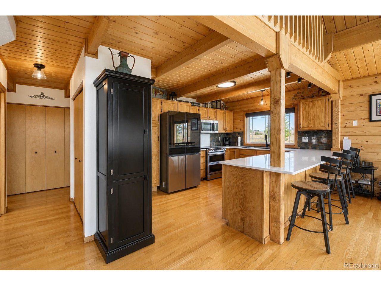 If you're feeling a little burned out by suburban life and want more breathing room - this is mountain living done RIGHT. Warm wood ceilings. Massive beams. Natural light pouring through every angle. Enormous windows that feel like you can see for miles. Big open spaces that still somehow feel cozy. The kind of house that immediately makes you feel at home.The great room is absolutely stunning with soaring vaulted ceilings, walls of windows, and a floorplan that was clearly designed for everyday life. You can picture everything here instantly: Slow mornings with coffee in the loft. Kids piled on the sectional after a day exploring Red Feather Lakes, dragging the day's catch from the private ponds. Snow gently falling outside the family room as you cut the turkey on Thanksgiving day.And the kitchen? Exactly what you want in a mountain property. Bright. Open. Updated. Quartz counters, beautiful cabinetry, modern finishes, and enough warmth and character to still feel like a true Colorado retreat instead of a sterile remodel.Every bedroom feels peaceful and tucked away- like your own boutique lodge suite. Crisp finishes, soft natural light, and windows that constantly pull the outdoors in without the house ever feeling dark. All the bathrooms have been recently renovated with mountain modern finishes for a touch of luxury.Truly though -  you may rarely even make it inside, because sitting outside on 5 glorious acres with sweeping mountain views might become your entire list of hobbies.The smell of pine and morning coffee on the expansive deck. Nights in the hot tub under a sky full of stars. ATV rides through the property. Watching wildlife wander through the trees. It's private without feeling isolated and peaceful without sacrificing comfort. You're 45 minutes-ish from Fort Collins for all your necessities and shopping but a world away at the same time.