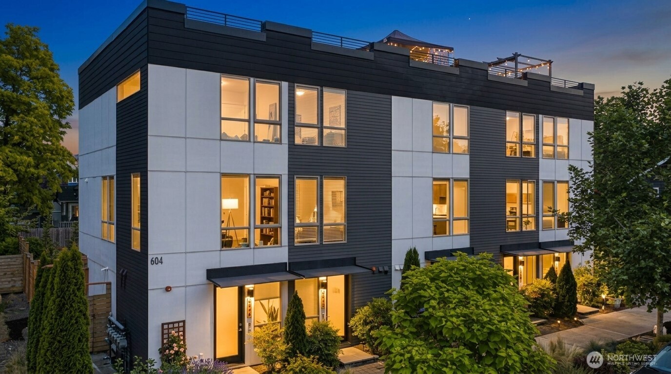 Modern contemporary living in this stunning 2019-built townhome, perfectly nestled between the vibrant neighborhoods of Ballard and Phinney Ridge. Boasting 3 bedrooms, 2.5 bathrooms, and 1,520 square feet of beautifully distributed multi-level living space, this standalone feel home offers both urban convenience and a peaceful neighborhood vibe.The main level welcomes you with streaming natural light, durable laminate flooring, and an open layout ideal for entertaining. A fully equipped kitchen features quality appliances, moving seamlessly into a comfortable dining and living area. Enjoy year-round comfort with high-efficiency central heating and A/C provided by a mini-split heat pump system.Retreat upstairs to find well-appointed bedrooms, including a flexible floor plan that easily accommodates a home office. The crowning jewel of this property is the expansive, private rooftop deck—perfect for summer BBQs while soaking in sweeping, panoramic views of the Seattle cityscape, Mt. Rainier, and the Olympic Mountains. No HOA fees, Designated off-street parking, and Steps from local favorites, parks, and quick transit links to downtown SeattleWhether you are looking for a turnkey primary residence or a high-yield investment property with flexible rental potential, this contemporary gem is a rare find. Welcome home!