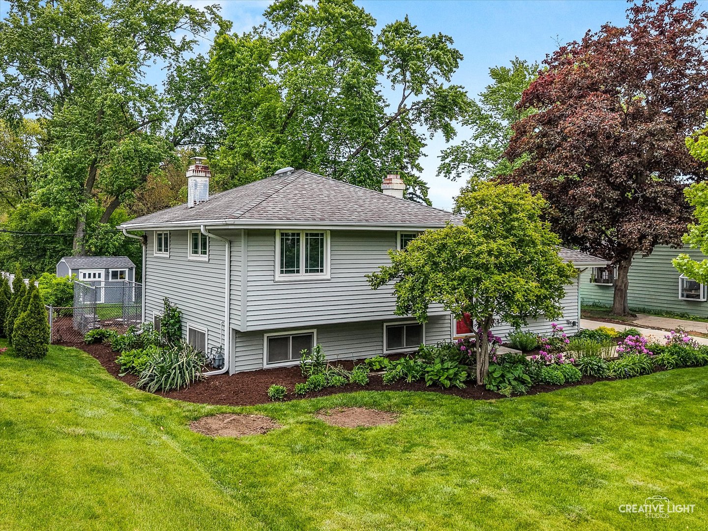 MULTIPLE OFFERS RECEIVED.... HIGHEST AND BEST DUE 5/18 BY 10PM.....Welcome to this beautifully maintained split-level home featuring new paint colors, 3 spacious bedrooms and 2 updated bathrooms. Hardwood flooring flows throughout the main living areas, creating a warm and inviting atmosphere. The thoughtfully updated kitchen is designed for both style and functionality, offering a large granite island, custom cabinetry with under-cabinet and in-cabinet lighting, a built-in beverage cooler, and abundant storage space. Both bathrooms have been tastefully updated with newer flooring, vanities and fixtures, and the lower-level living area features a charming wood-burning stove, perfect for added comfort and ambiance. The expansive laundry room provides excellent additional storage and workspace. Step outside to a fully fenced and professionally landscaped backyard complete with a large concrete patio, ideal for entertaining, along with a custom-built Tuff Shed for secure extra storage. Newer Andersen casement windows and patio doors fill the home with natural light, while newer vinyl siding enhances curb appeal and low-maintenance living. An extra-long concrete driveway to the oversized 2.5 car detached garage offers ample parking space. With a recent furnace and A/C, this home combines modern updates with everyday comfort in a highly desirable location. Conveniently situated near schools, shopping, restaurants, I-88/ I-355, and the Metra station, commuting to downtown Chicago is approximately 30 minutes away.